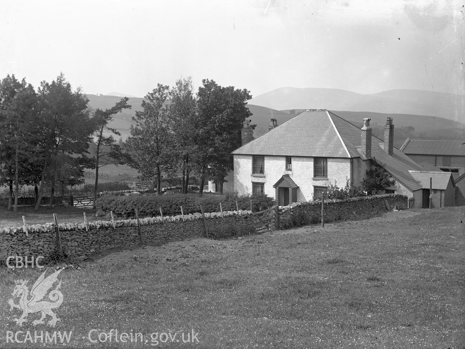 Black and white glass negative showing an unidentified house and buildings.