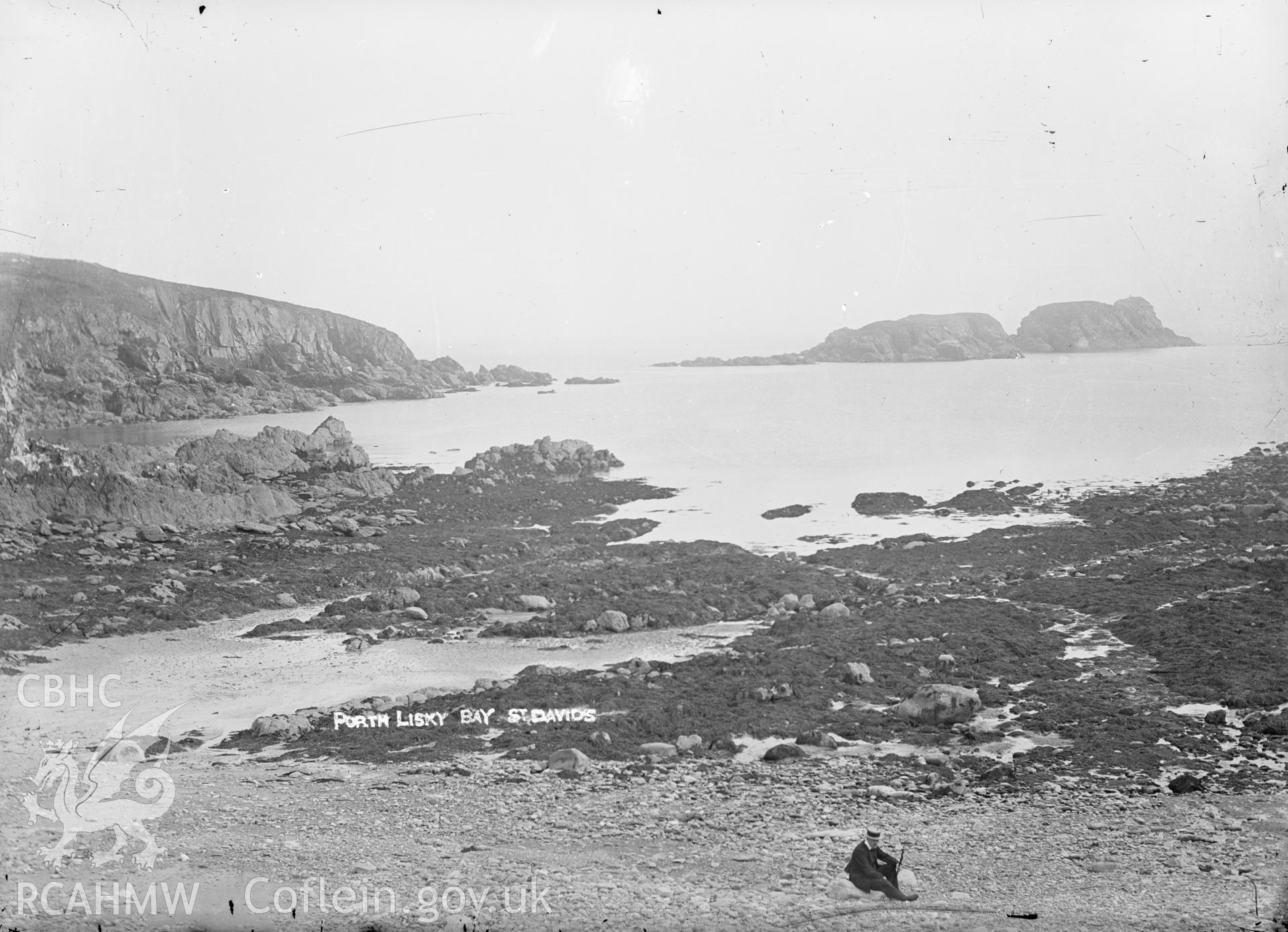 Black and white glass negative showing figure on the beach at Porth Lisky bay at St Davids.