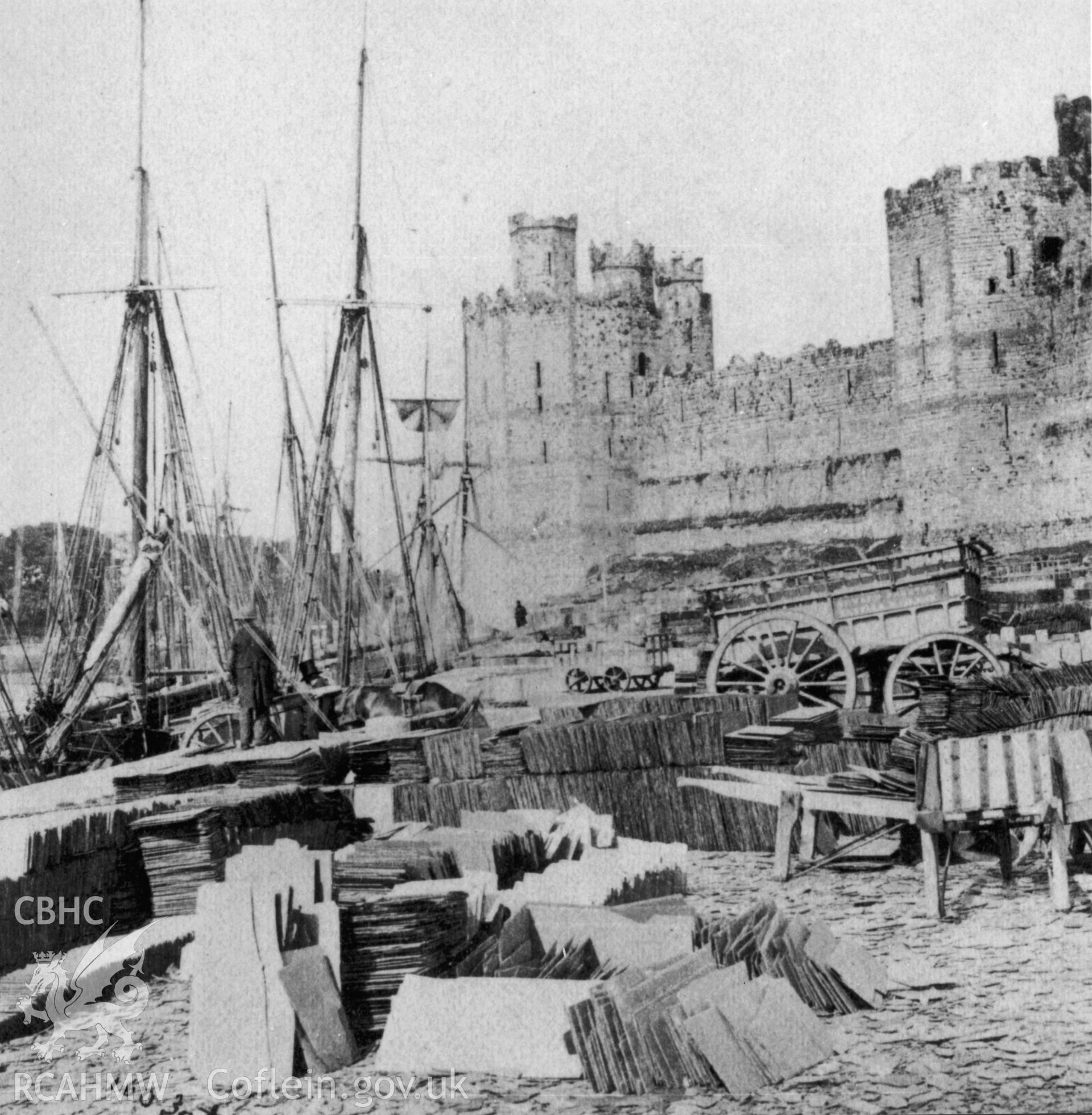 Caernarfon Castle; photograph showing the castle and harbour with slate piles in the foreground.