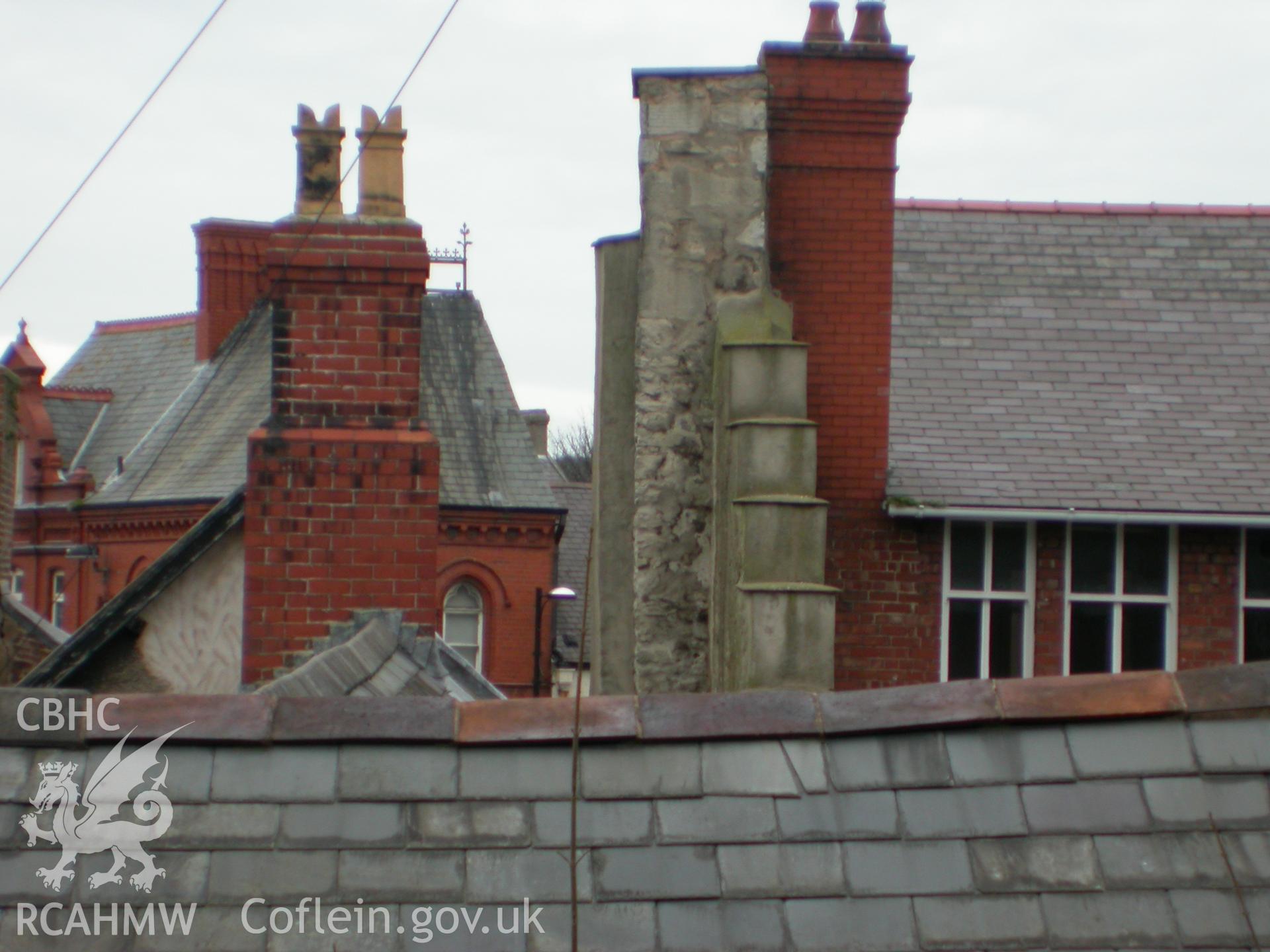 Stone chimney to hall against post office building.