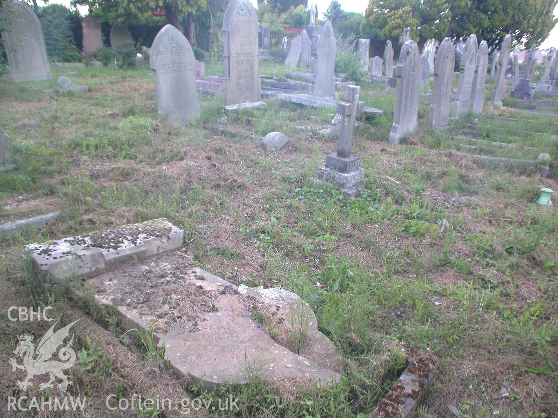 Toppled gravestone of wife of Thomas Thomas chapel architect, his grave beyond.