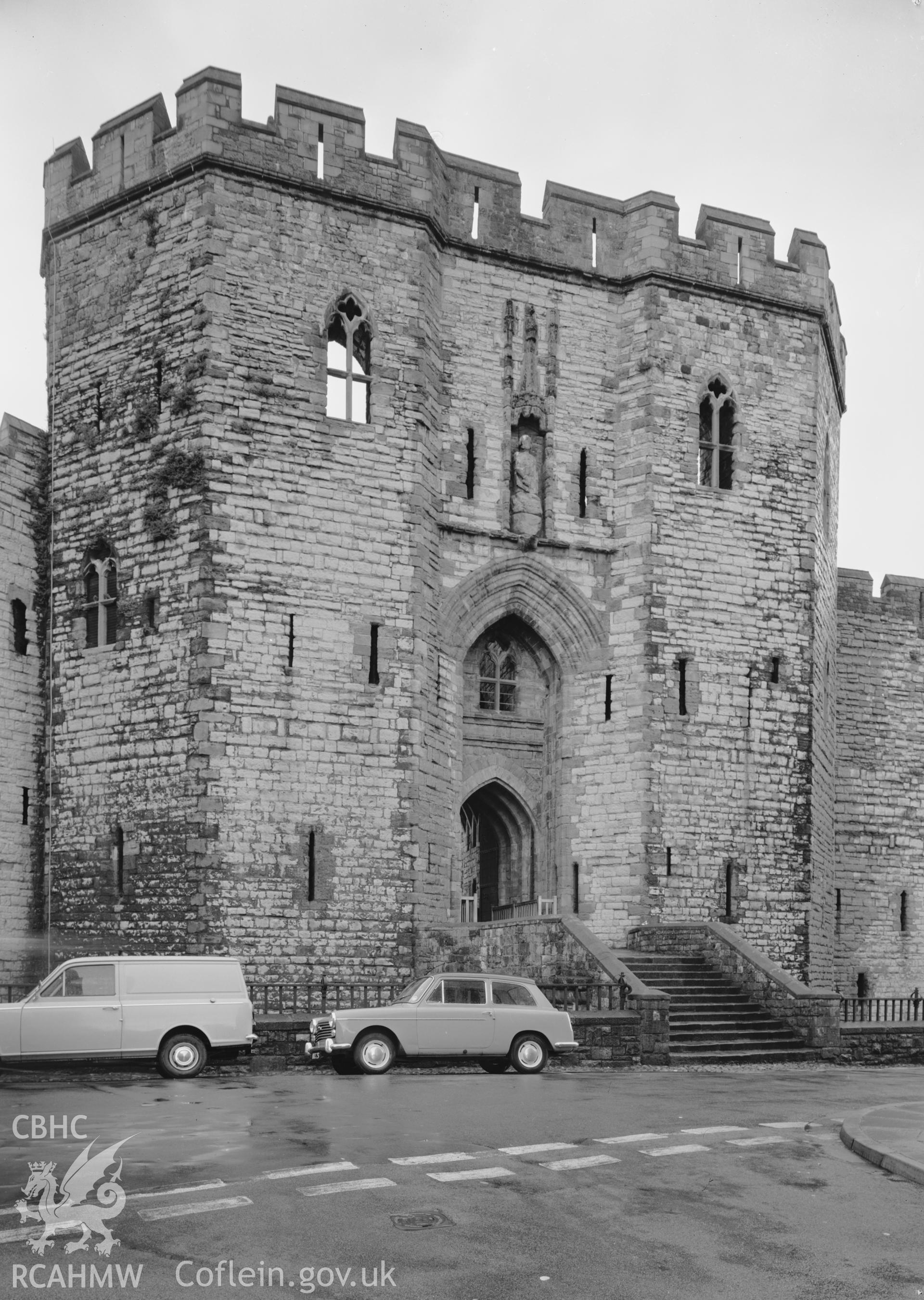 D.O.E photograph of Caernarfon Castle - Kings Gate, parked cars prominent in foreground.