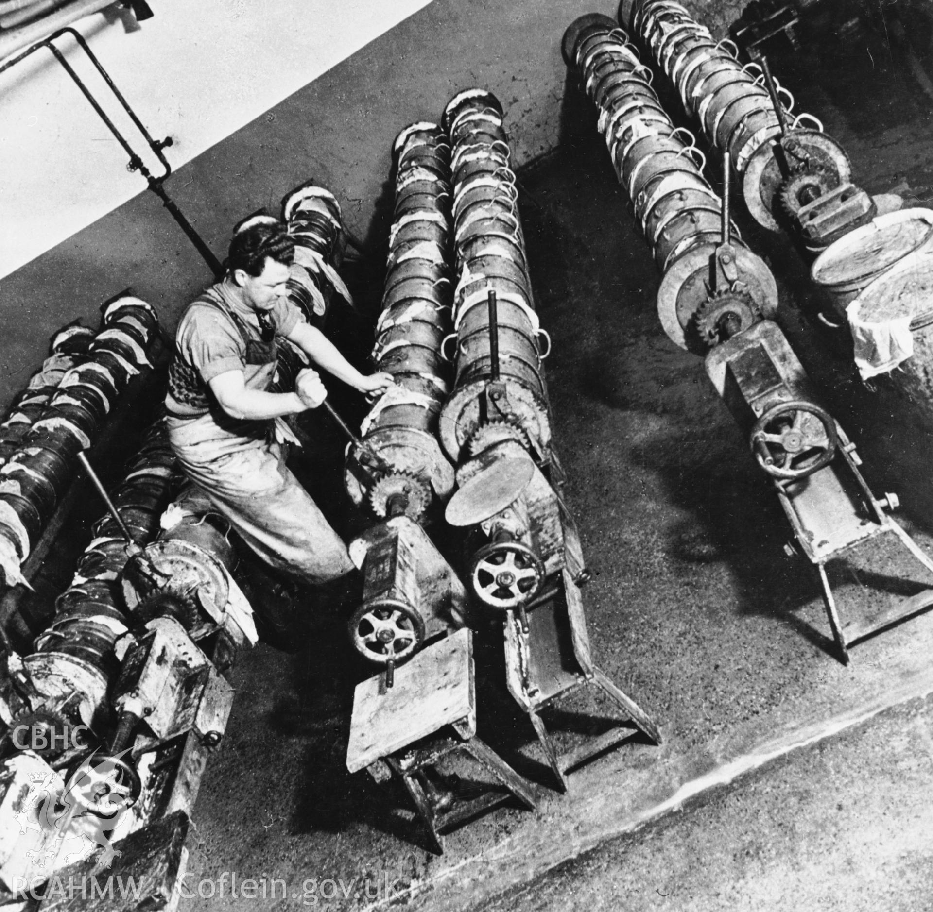 Copy of a pre-1950 photo showing metal moulds used in cheese production