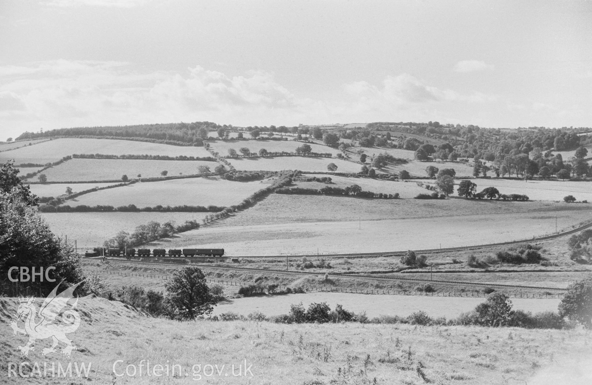 Black and white photograph showing Aberayron Junction looking west, with milk train coming off the Aberayron Branch and joining the main line towards Lampeter; produced by Arthur Chater in 1966, part of a larger collection which has not yet been fully catalogued.