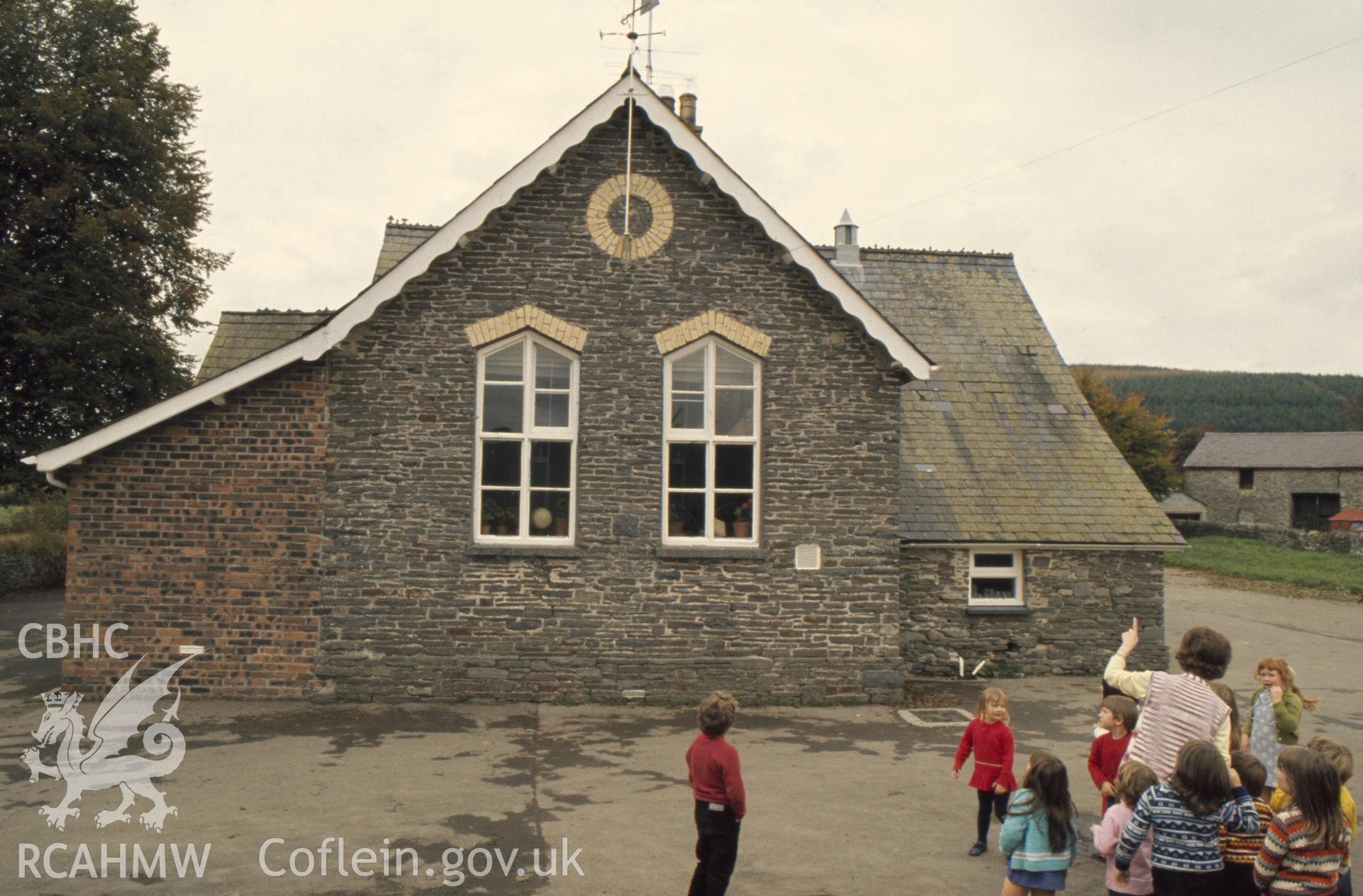 Colour photographic transparency showing Llangybi school, Ceredigion, with children playing; collated by the former Central Office of Information.