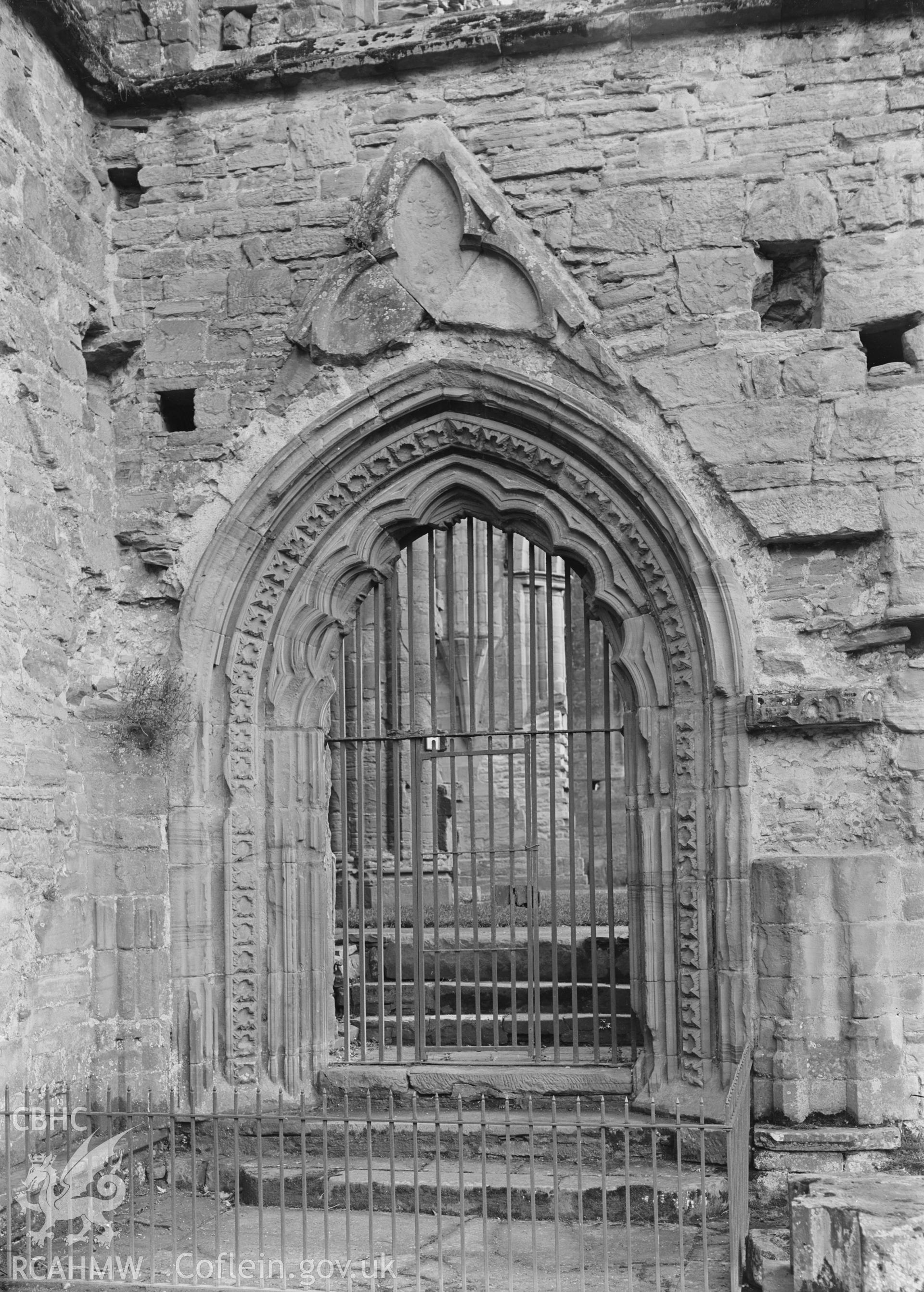 Black and white glass negative showing arched entrance at Tintern Abbey.