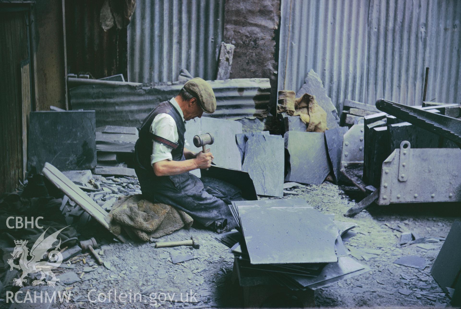 Colour 35mm slide of Oakley Slate Quarry Blaenau Ffestiniog, showing slateworker splitting slate, by Dylan Roberts, undated.