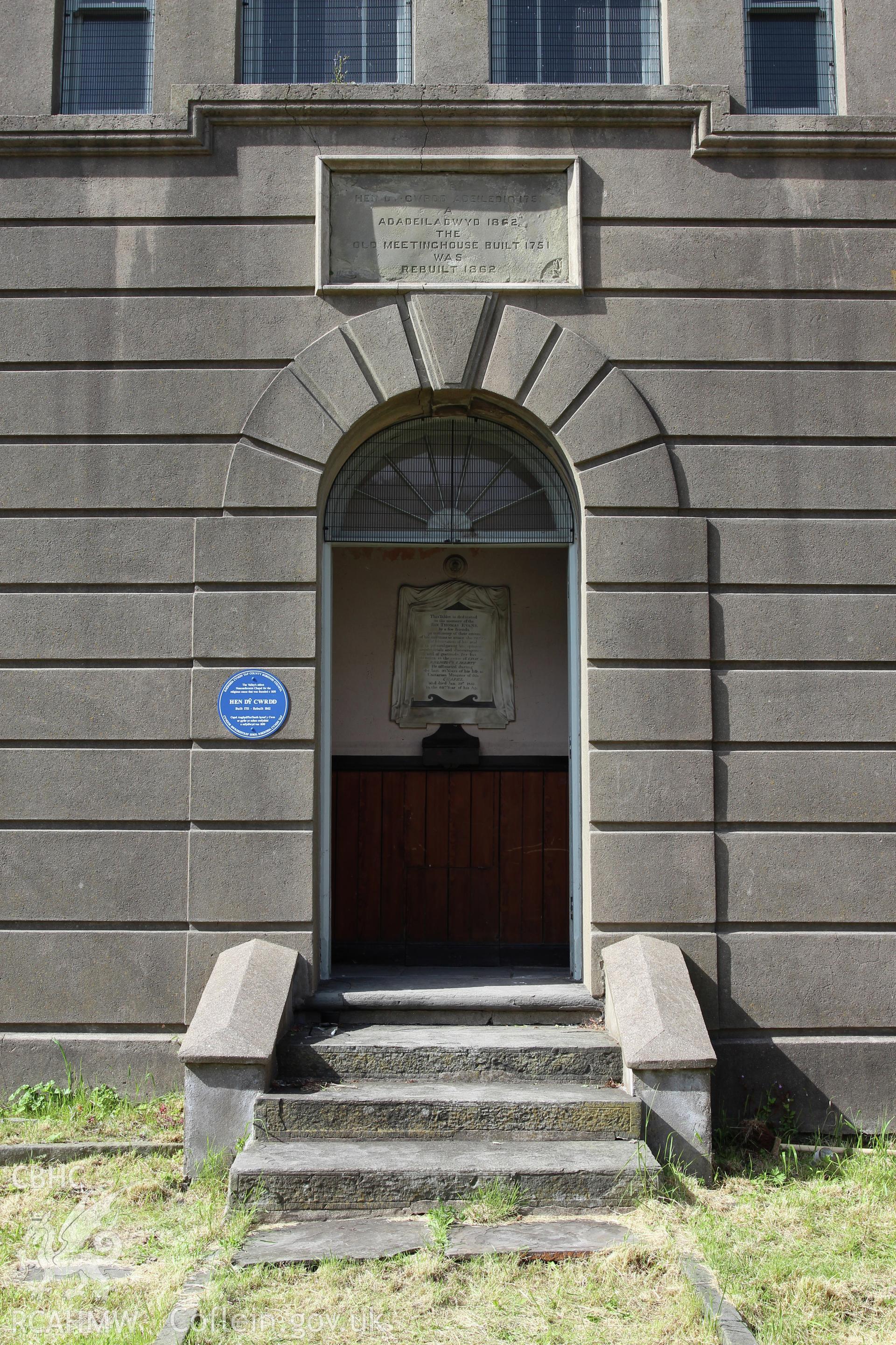 Detail of central doorway in facade, including blue plaque and name/dateston