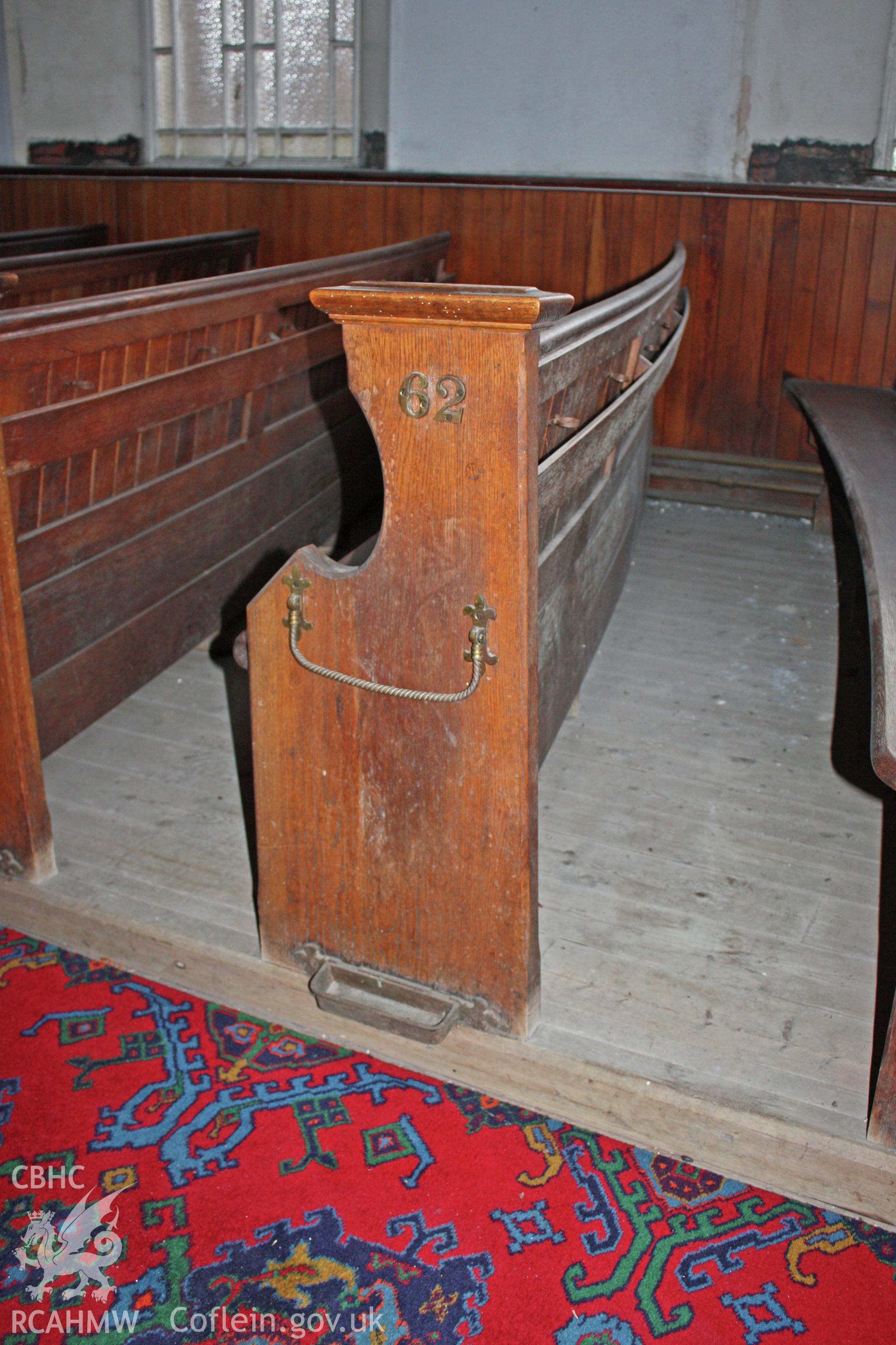 Detail of ground floor pew with numbering and umbrella stand