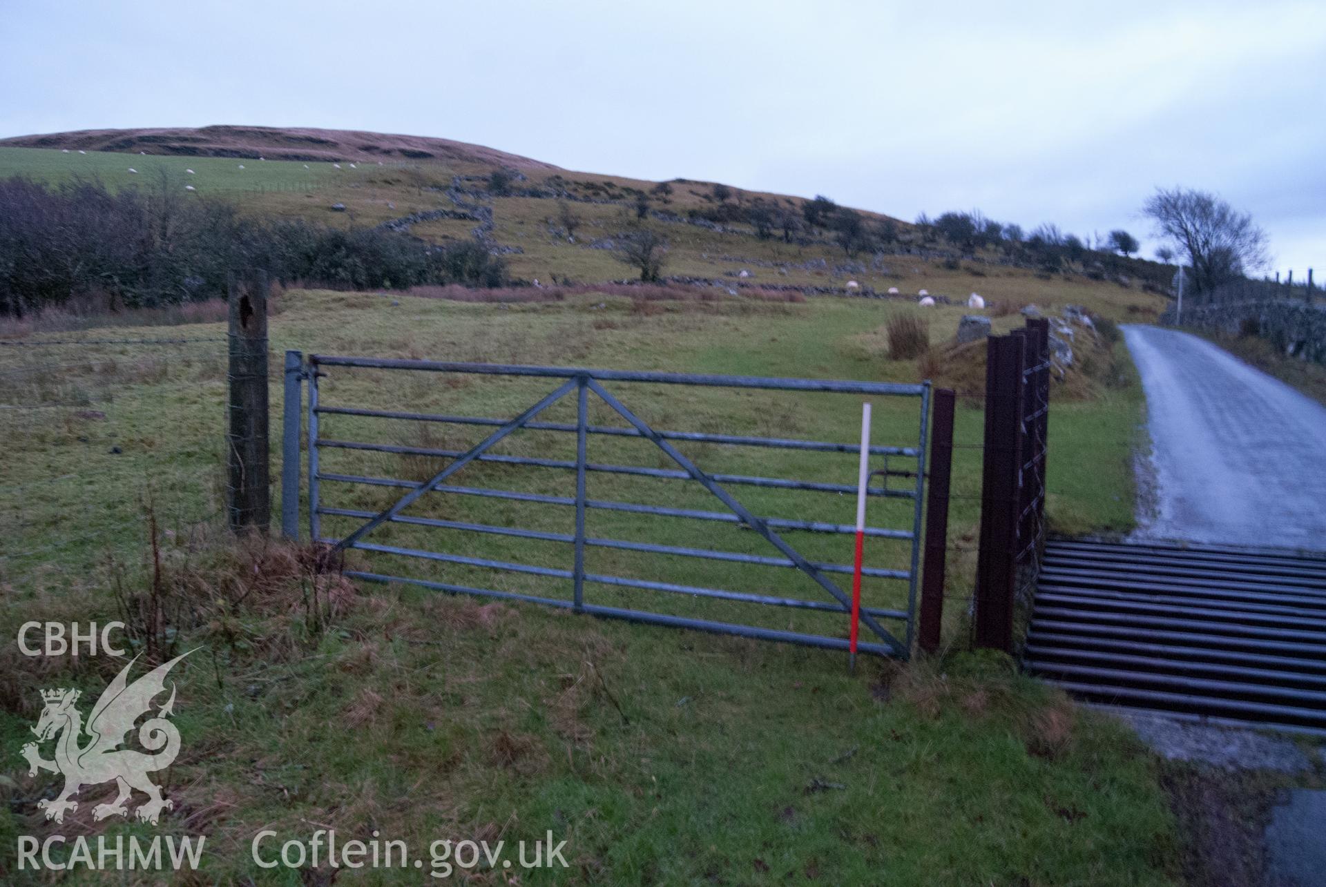 View from north-west, showing view of point where pipeline crosses onto other side of road, just before cattle grid near Erw Gain farmhouse