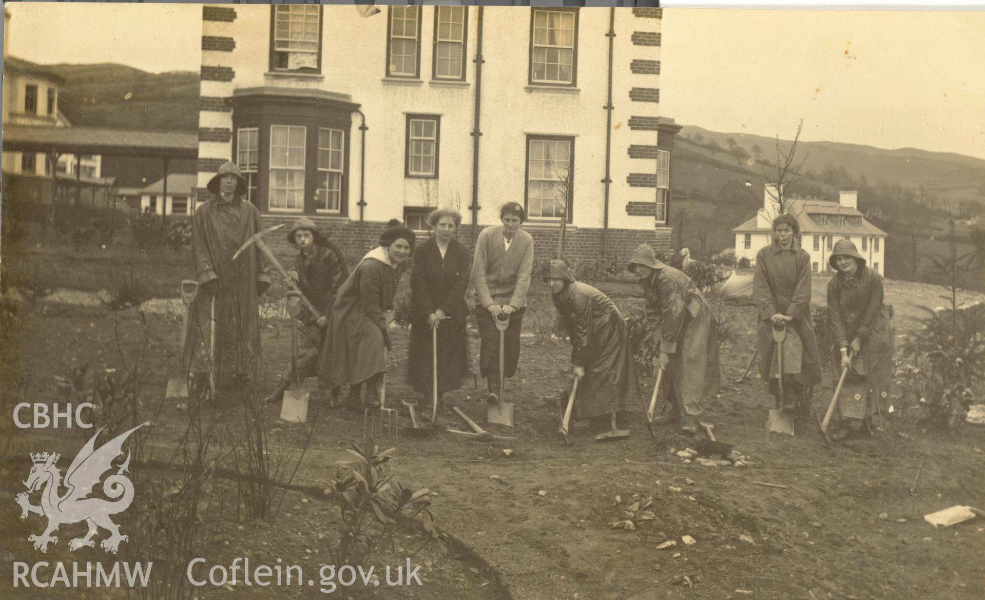 Digitised postcard image of a group of 'Land Girls' gardening at Llangwyfan Hospital, Llandynog. Produced by Parks and Gardens Data Services, from an original item in the Peter Davis Collection at Parks and Gardens UK. We hold only web-resolution images of this collection, suitable for viewing on screen and for research purposes only. We do not hold the original images, or publication quality scans.