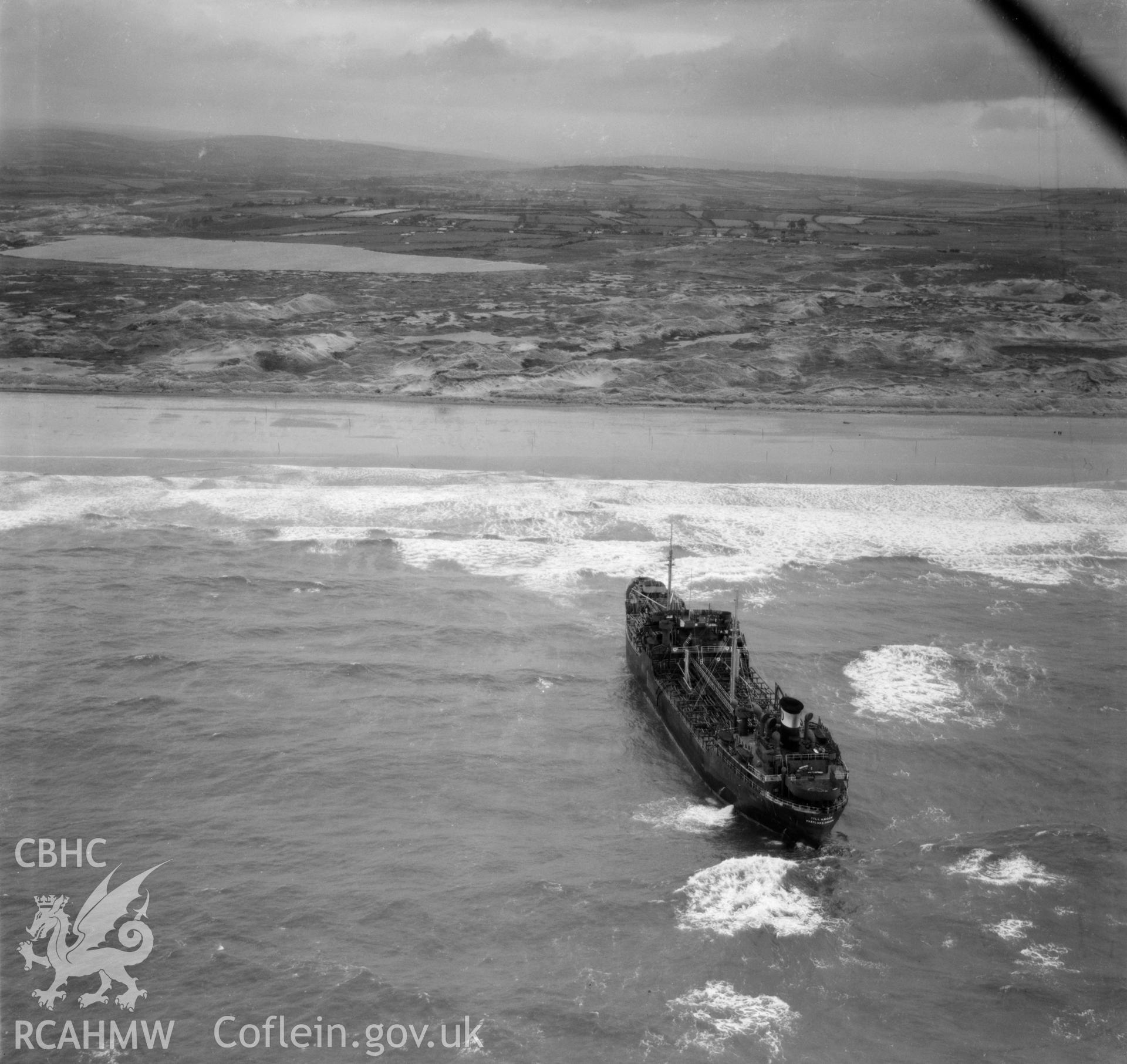 View of the beached ship Tillamook, a memorial to which was erected at the Prince of Wales Inn, Kenfig. Oblique aerial photograph, 5?" cut roll film.