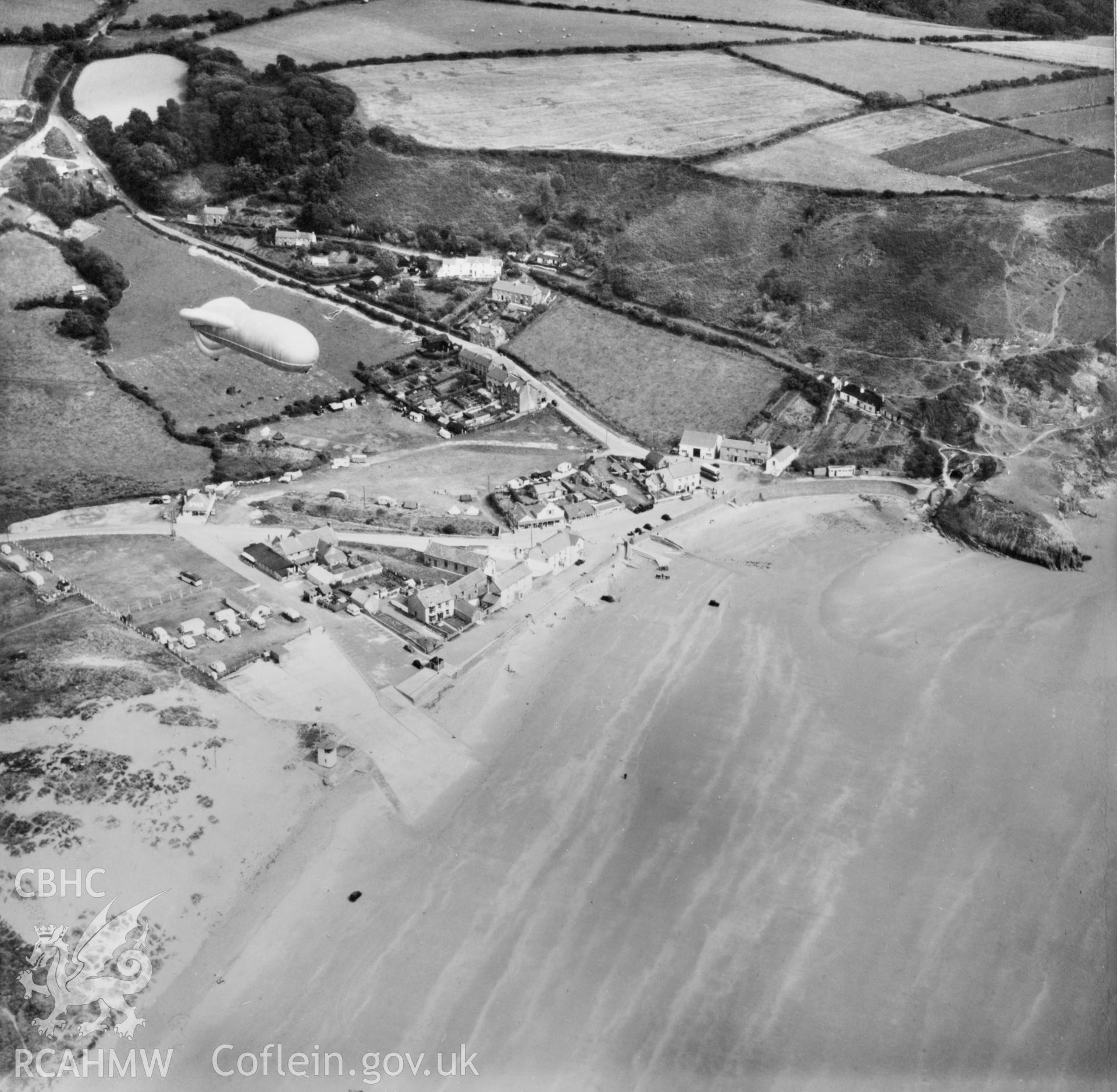 View of Pendine showing caravans, cars and a barrage balloon (reversed). Oblique aerial photograph, 5?" cut roll film.