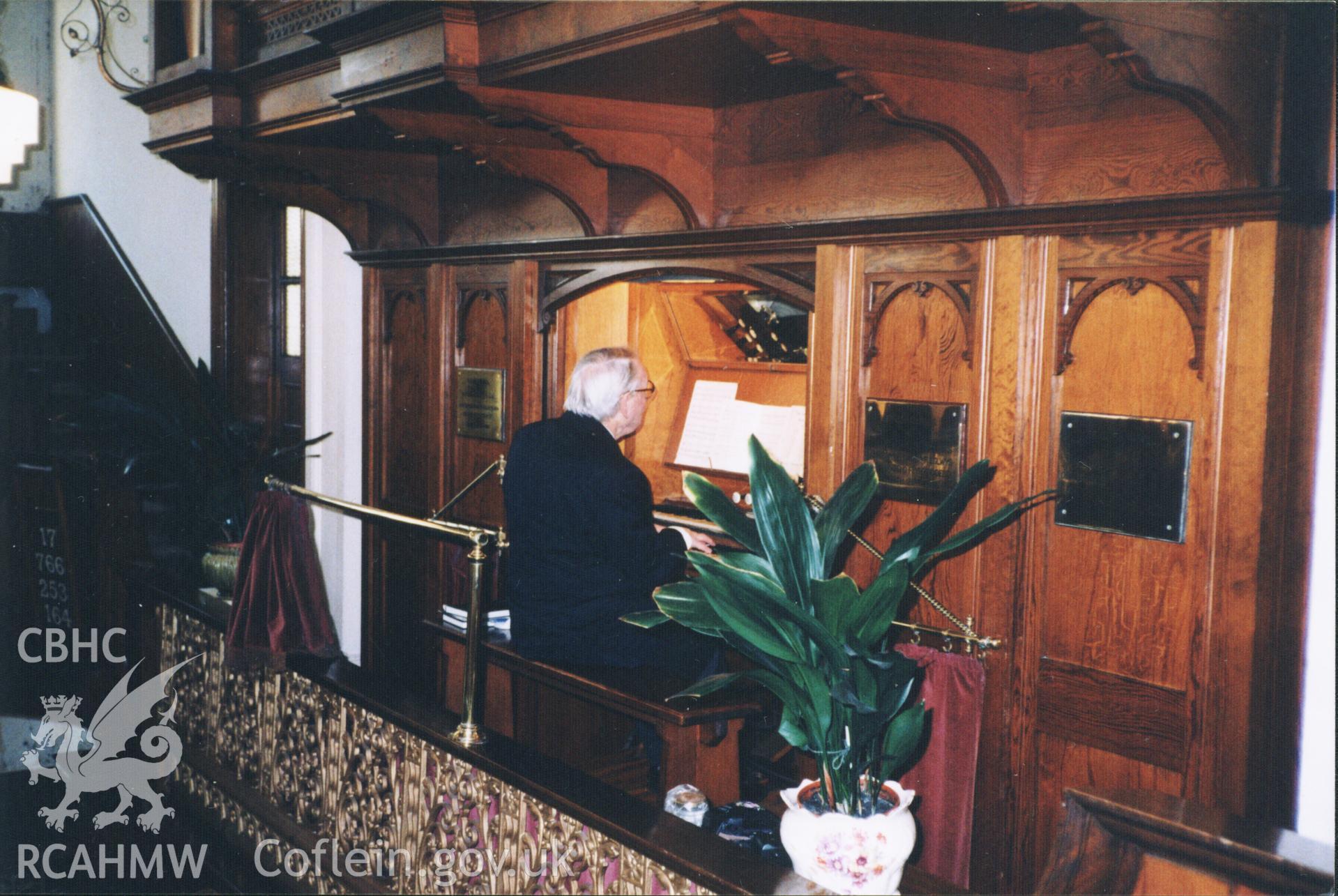 Colour photograph of past organist Aneurin Thomas, playing the organ for the last time, 2003. Donated to the RCAHMW by Cyril Philips as part of the Digital Dissent Project.