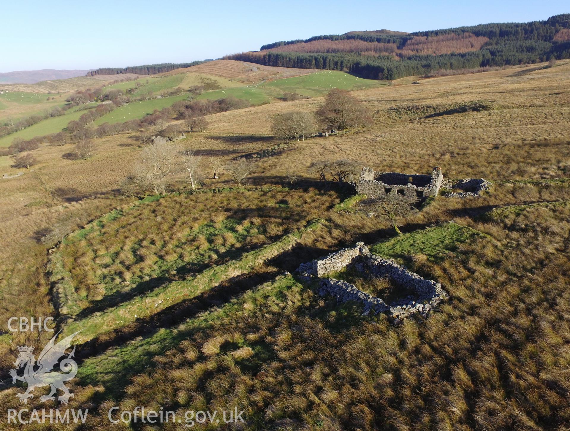 Aerial view showing remains of doorway, window spaces and chimney piece at Tynewydd stone cottage, as well as the ruined outbuilding to its west, south west of Bryneithinog farm, Ystrad Fflur. Colour photograph taken by Paul R. Davis on 18th November 2018.