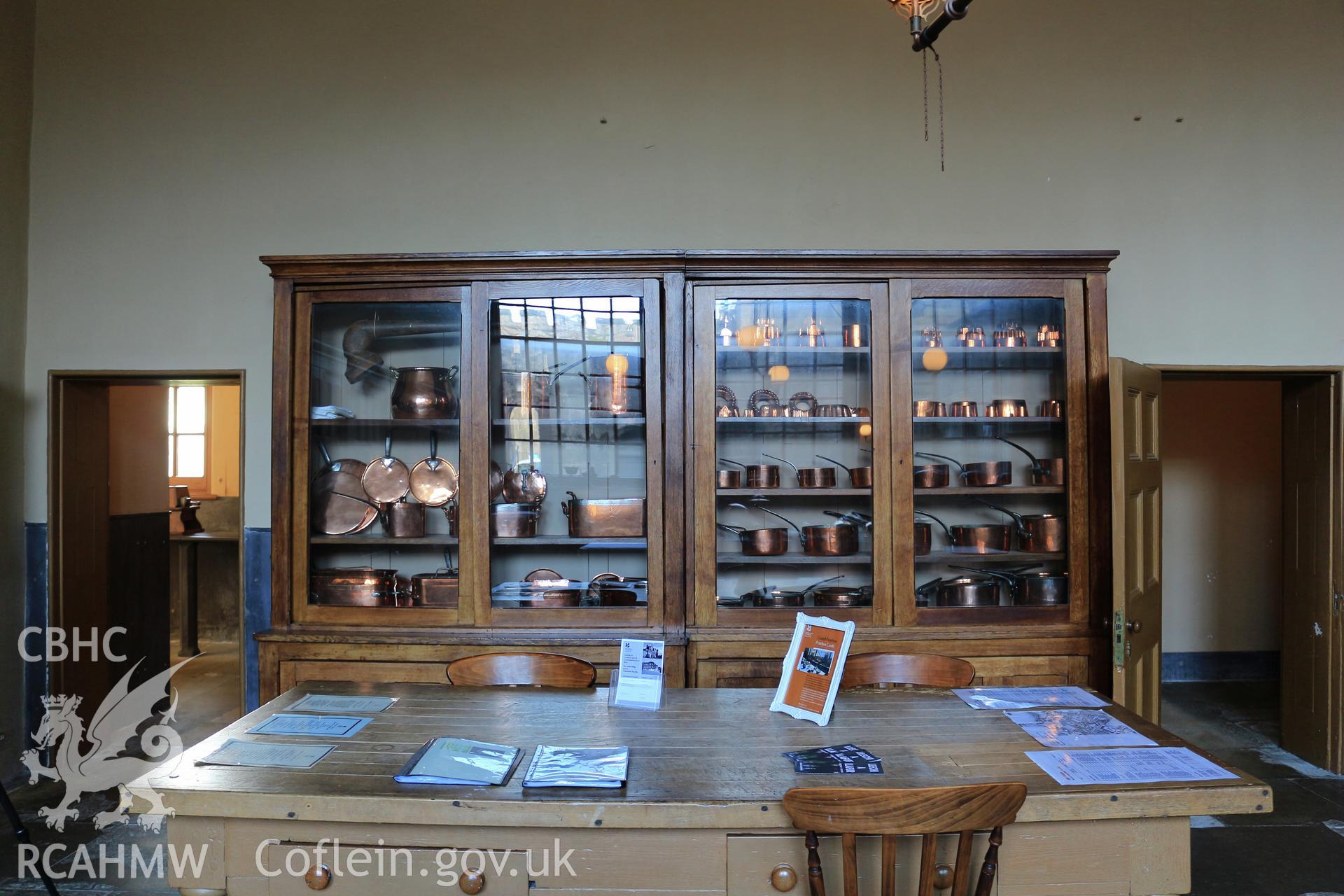 Photographic survey of Penrhyn Castle, Bangor. Kitchens, table and cabinet with copper pots.