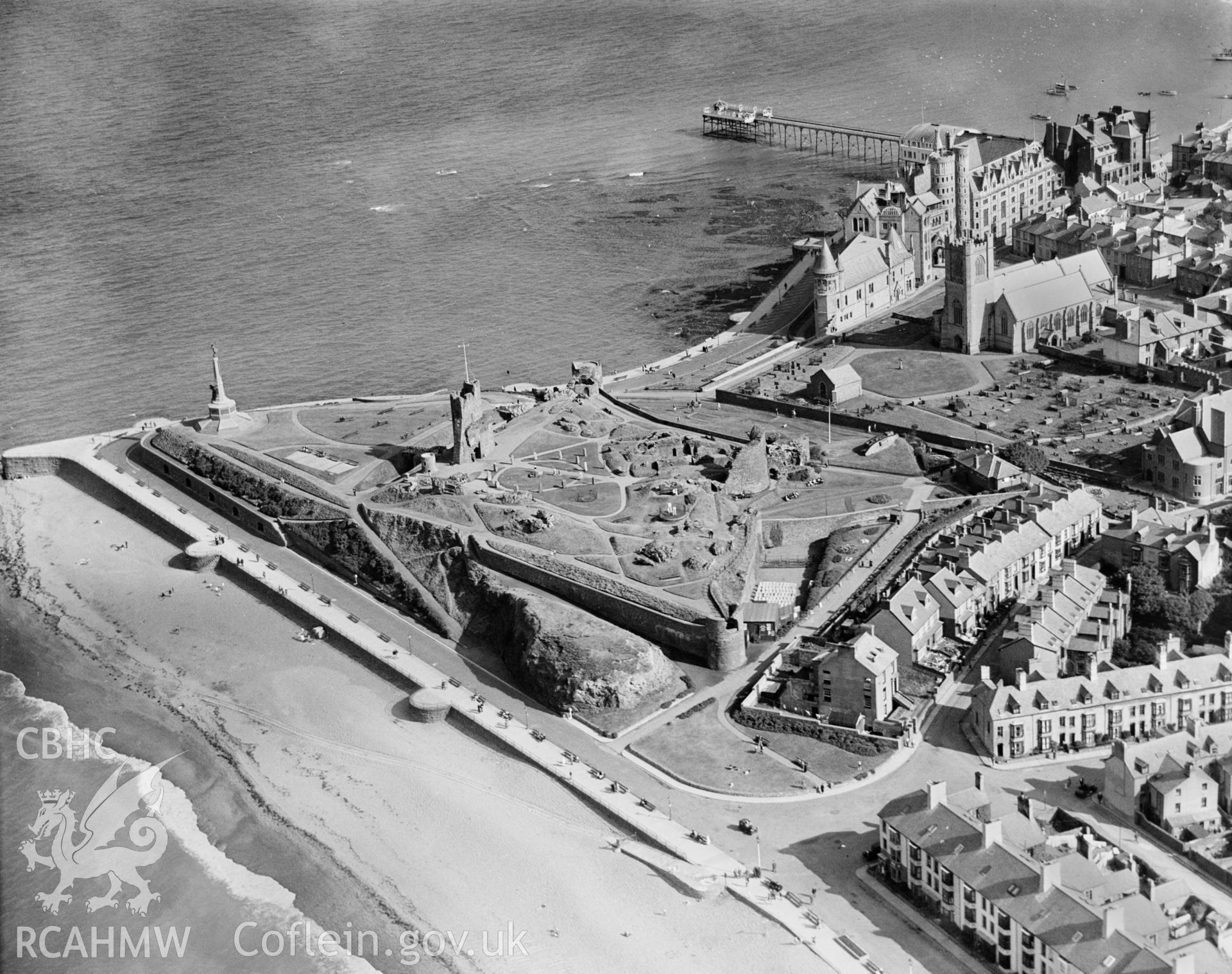 General view of Aberystwyth showing the castle, Old College, Pier, St Michael's church, war memorial, note also the Great War tank presented to the town as appreciation of fund-raising efforts of the townspeople, oblique aerial view. 5? x 4? black and white glass plate negative.