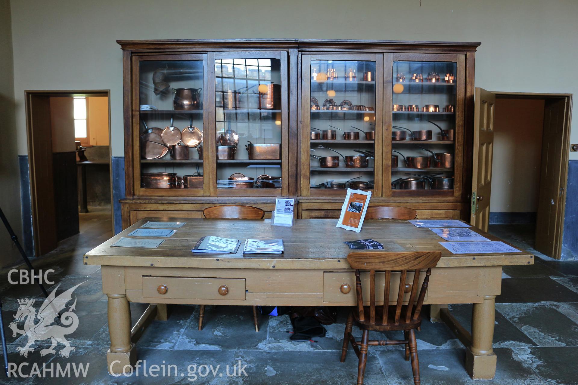 Photographic survey of Penrhyn Castle, Bangor. Kitchens, table and cabinet with copper pots.