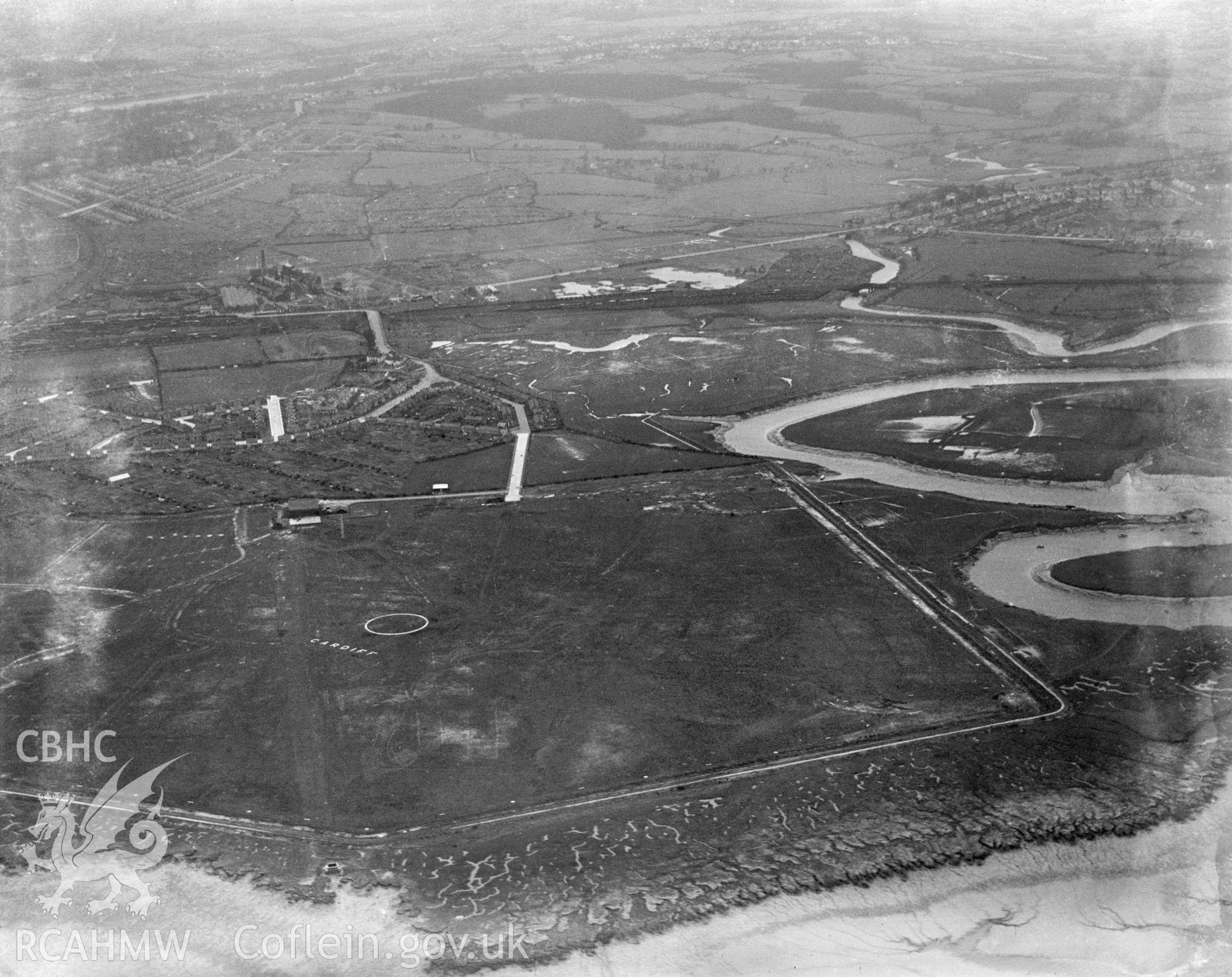 Digital copy of a black and white, oblique aerial photograph of Cardiff Aerodrome. The photograph shows a view of Cardiff Municipal Airport, as it was then known, from the South East.