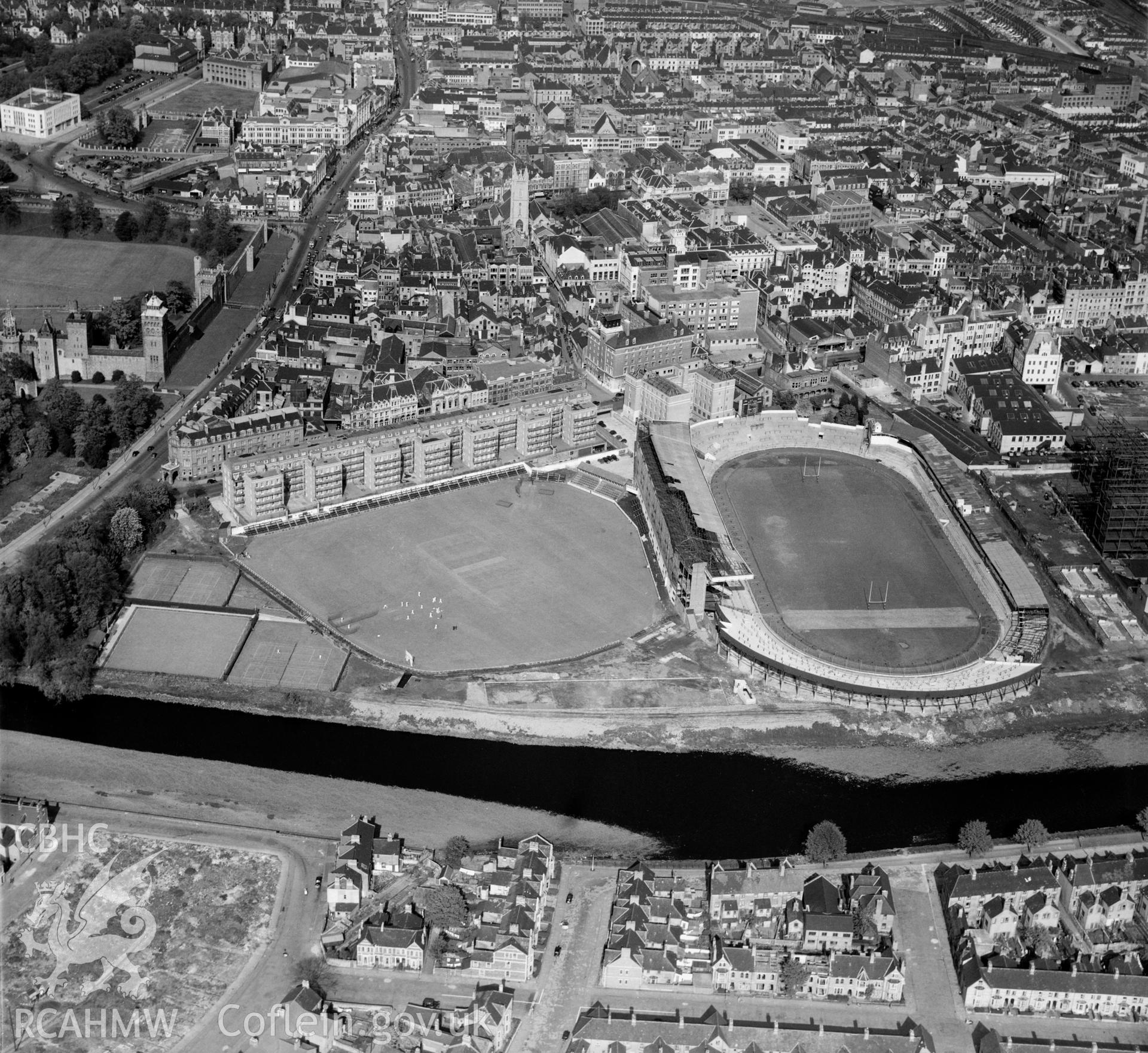 Digital copy of a black and white, oblique aerial photograph of Cardiff Arms Park. The photograph shows a view from the West showing the new North stand under construction.