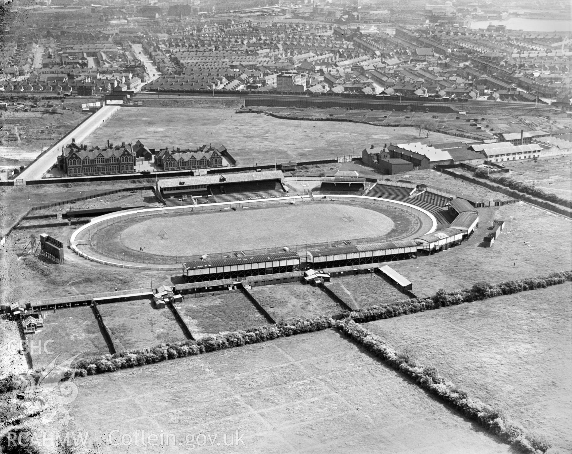 View of greyhound racing track, Sloper Road, Cardiff showing Ninian Park Schools, oblique aerial view. 5?x4? black and white glass plate negative.