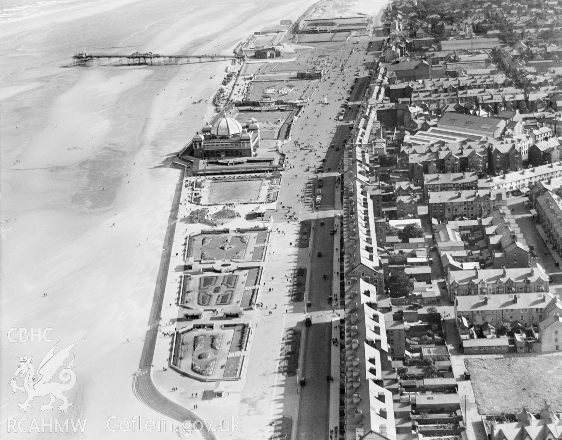 View of Rhyl showing promenade, pier, bandstand, pleasure gardens and open air swimming pool, oblique aerial view. 5?x4? black and white glass plate negative.
