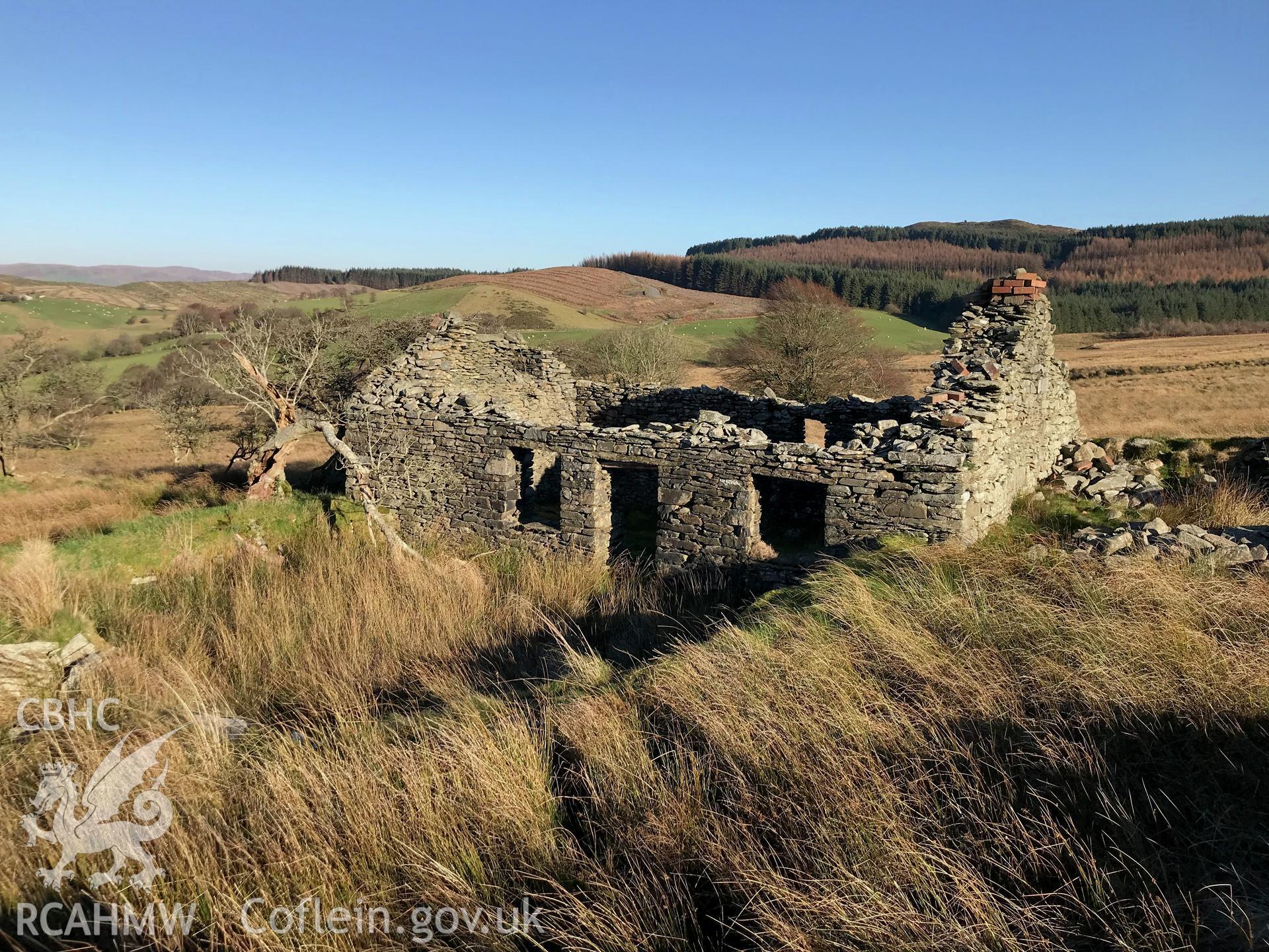 Exterior side elevation showing remains of doorway, window spaces and chimney piece of Tynewydd stone cottage, which is south west of Bryneithinog farm, Ystrad Fflur. Colour photograph taken by Paul R. Davis on 18th November 2018.