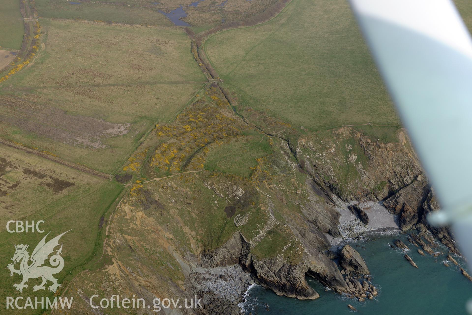 Aerial photography of Watery Bay Rath taken on 27th March 2017. Baseline aerial reconnaissance survey for the CHERISH Project. ? Crown: CHERISH PROJECT 2017. Produced with EU funds through the Ireland Wales Co-operation Programme 2014-2020. All material made freely available through the Open Government Licence.