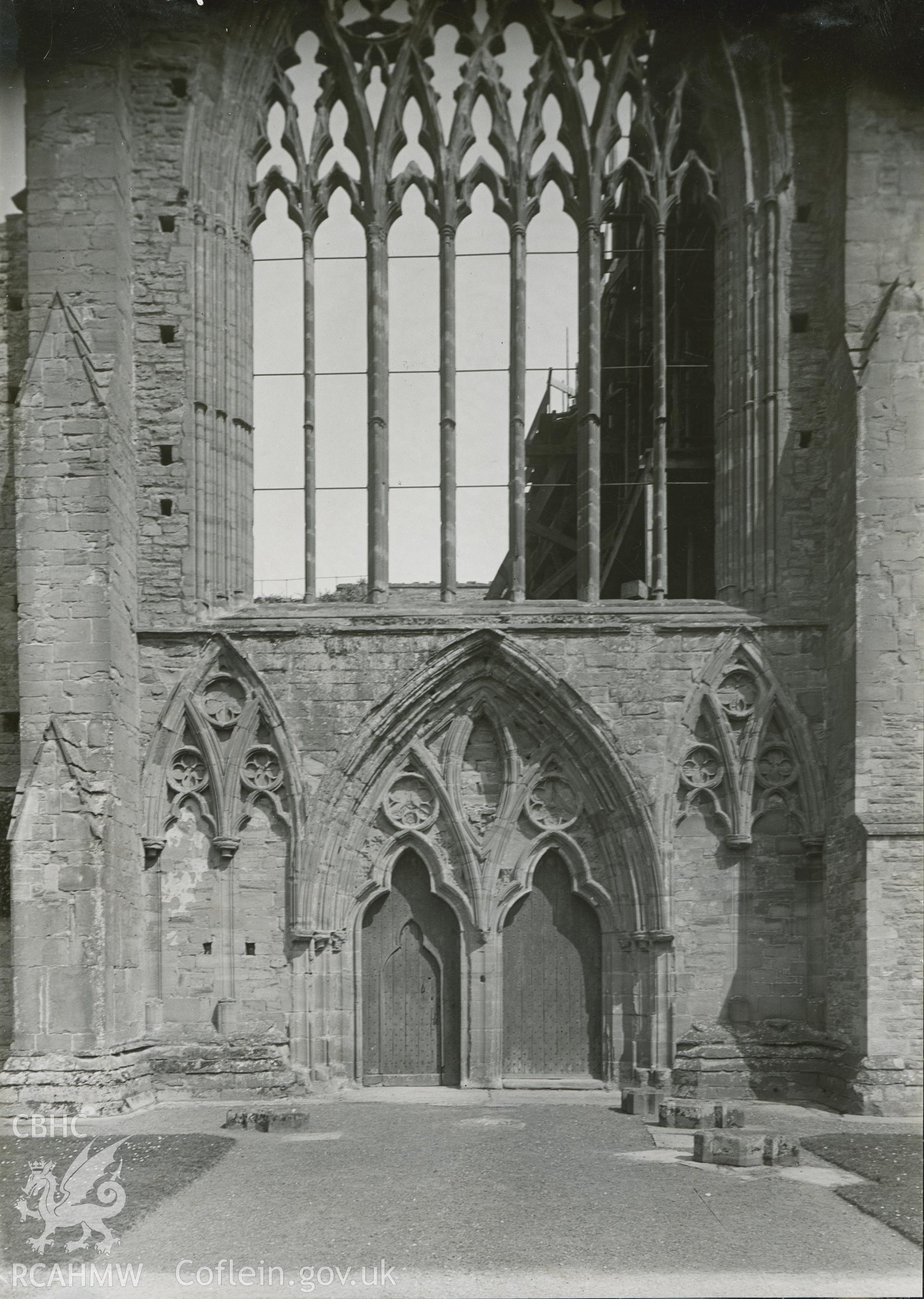 Digital copy of an exterior view of west window and entrance to Tintern Abbey.