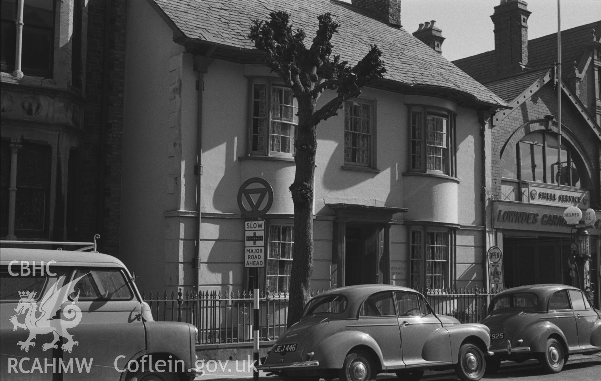Black and White photograph showing Sandmarsh Cottage and Lowndes Garage, Queens Road, Aberystwyth. Photographed by Arthur Chater in March 1961, from Grid Reference SN 5857 8188, looking east.