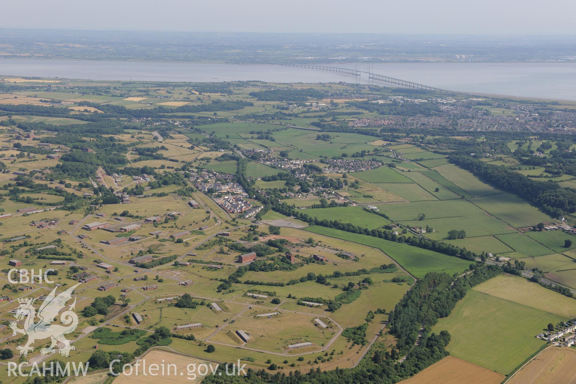 Royal Naval Propellant Factory, with Caerwent, then Caldicot, and finally the Second Severn Crossing beyond. Oblique aerial photograph taken during the Royal Commission?s programme of archaeological aerial reconnaissance by Toby Driver on 1st August 2013.