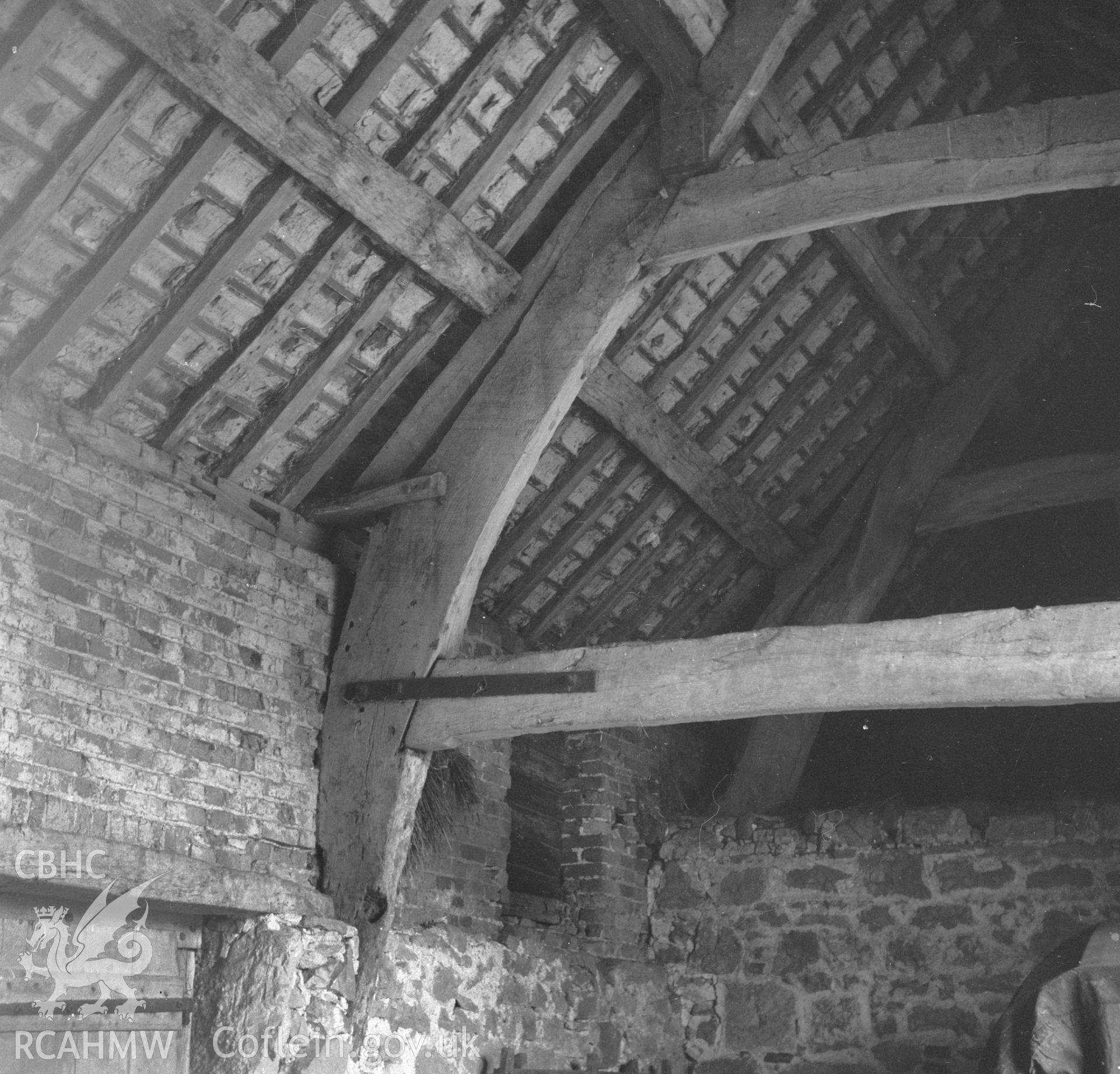 Digital copy of a black and white nitrate negative showing cruck timbers in the barn at Rhual.