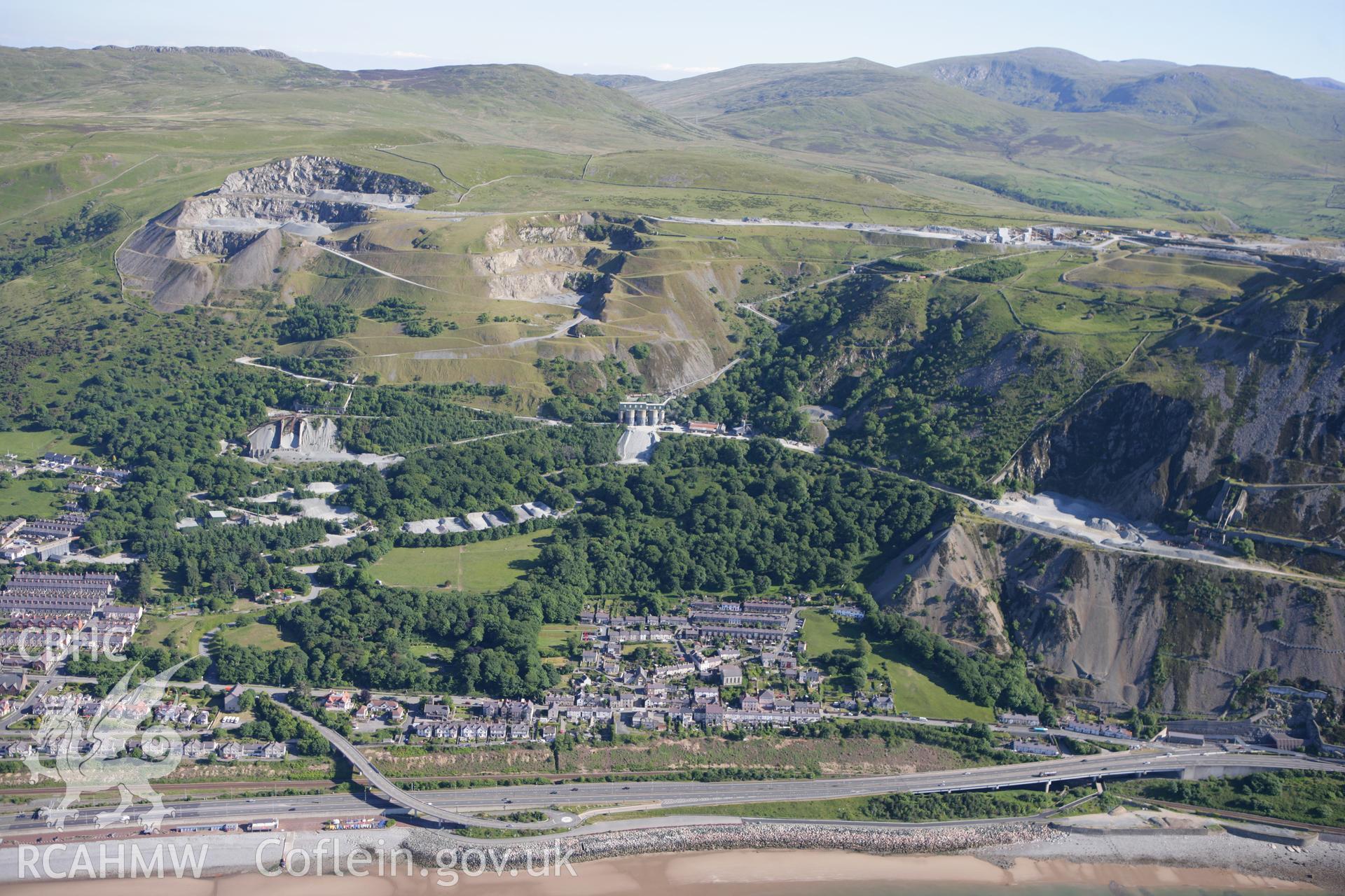 RCAHMW colour oblique photograph of Penmaenmawr Stone Quarry, with Penmaenmawr town below. Taken by Toby Driver on 16/06/2010.