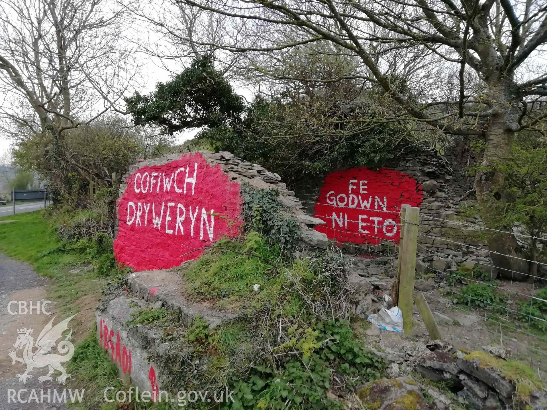 Digital colour photograph showing Cofiwch Dryweryn Wall, following vandalism, with additional message: 'Fe Godwn Ni Eto' painted on wall behind. Taken 15 April 2019.