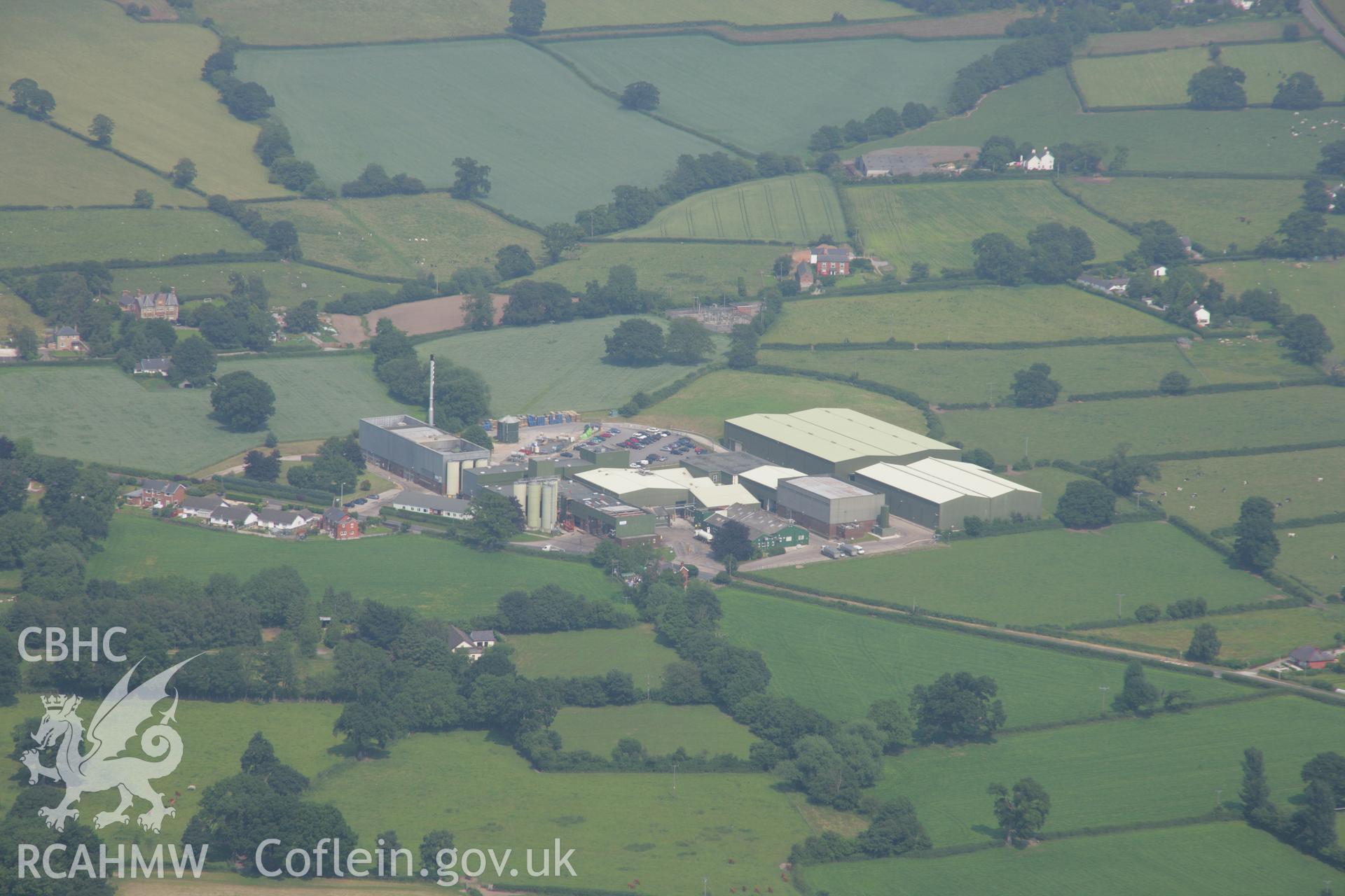 RCAHMW colour oblique aerial photograph of the creamery and cheese factory, Llandyrnog. Taken on 04 July 2006 by Toby Driver.