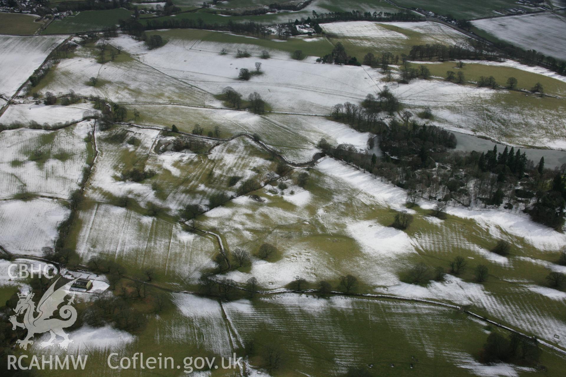 RCAHMW colour oblique aerial photograph of Rug Park from the north-west under melting snow. Taken on 06 March 2006 by Toby Driver.