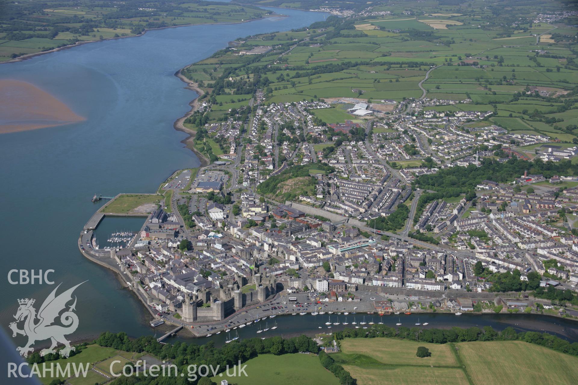 RCAHMW colour oblique aerial photograph of Caernarfon Castle and the walled town from the south-west. Taken on 14 June 2006 by Toby Driver.