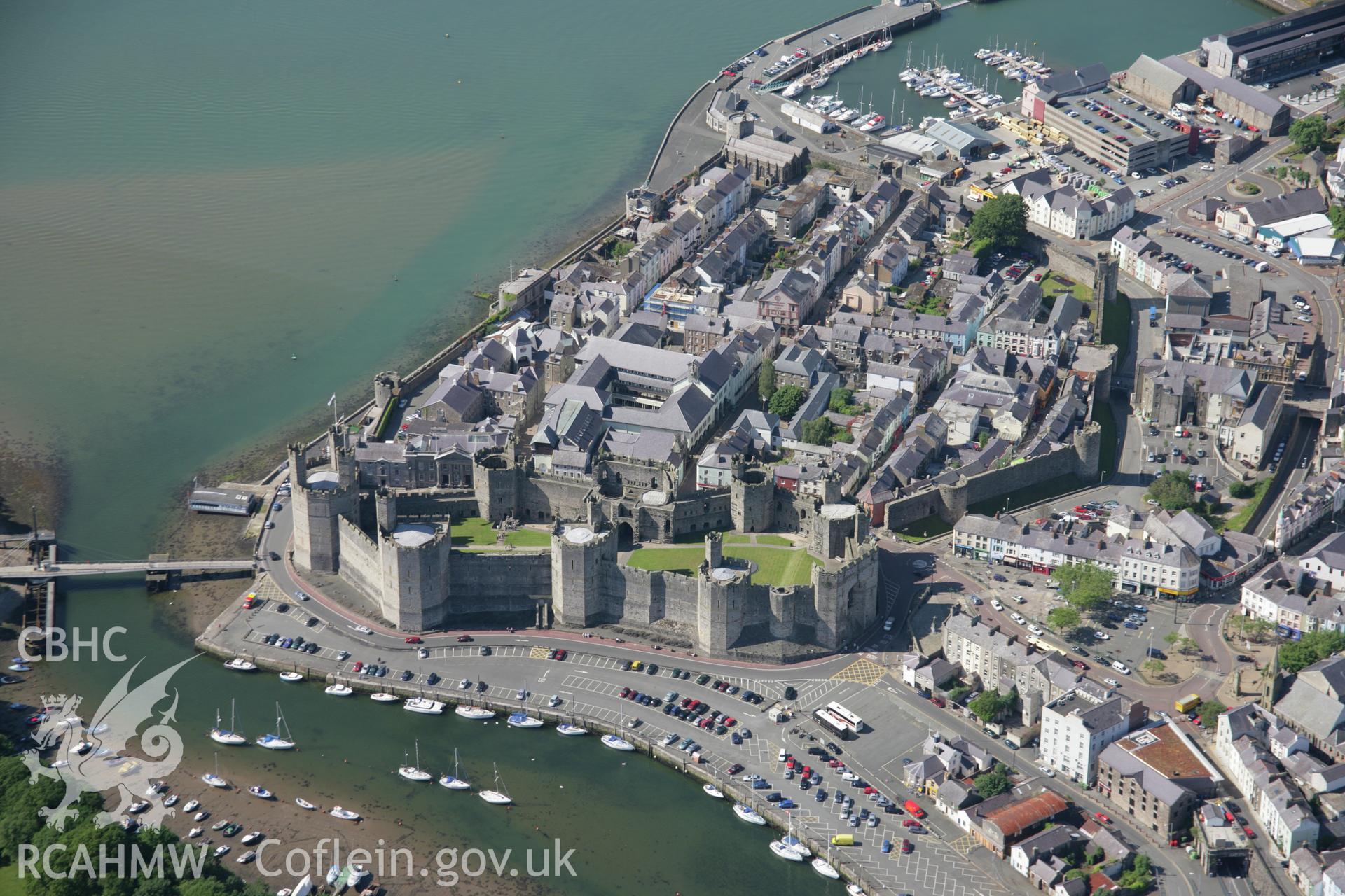 RCAHMW colour oblique aerial photograph of Caernarfon Castle and the walled town from the south. Taken on 14 June 2006 by Toby Driver.