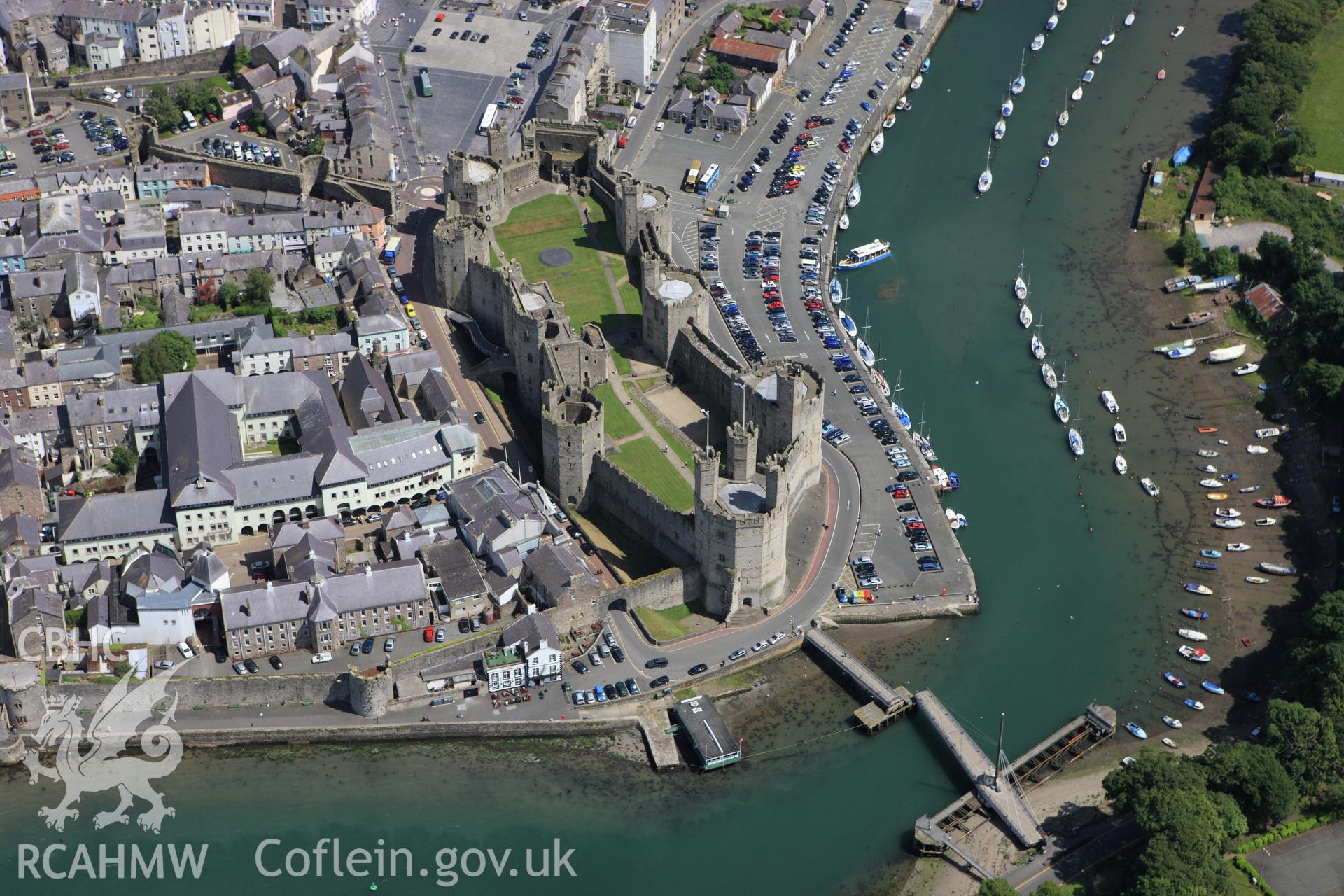 RCAHMW colour oblique aerial photograph of Caernarfon Castle and town. Taken on 16 June 2009 by Toby Driver