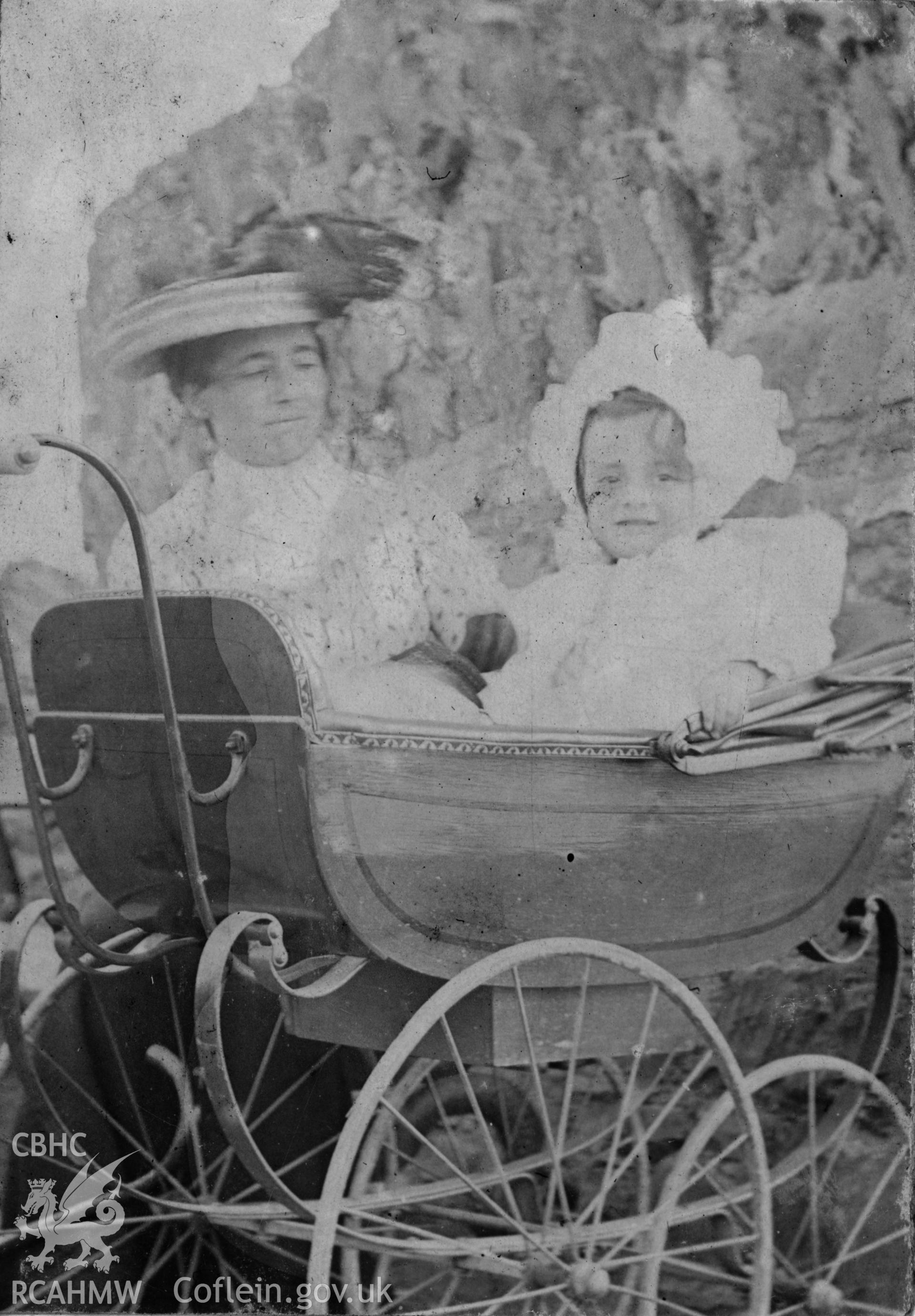"On Castle grounds 1904'". Photo of adult and baby in a pram, digitised from a photograph album showing views of Aberystwyth and District, produced by David John Saer, school teacher of Aberystwyth. Loaned for copying by Dr Alan Chamberlain.