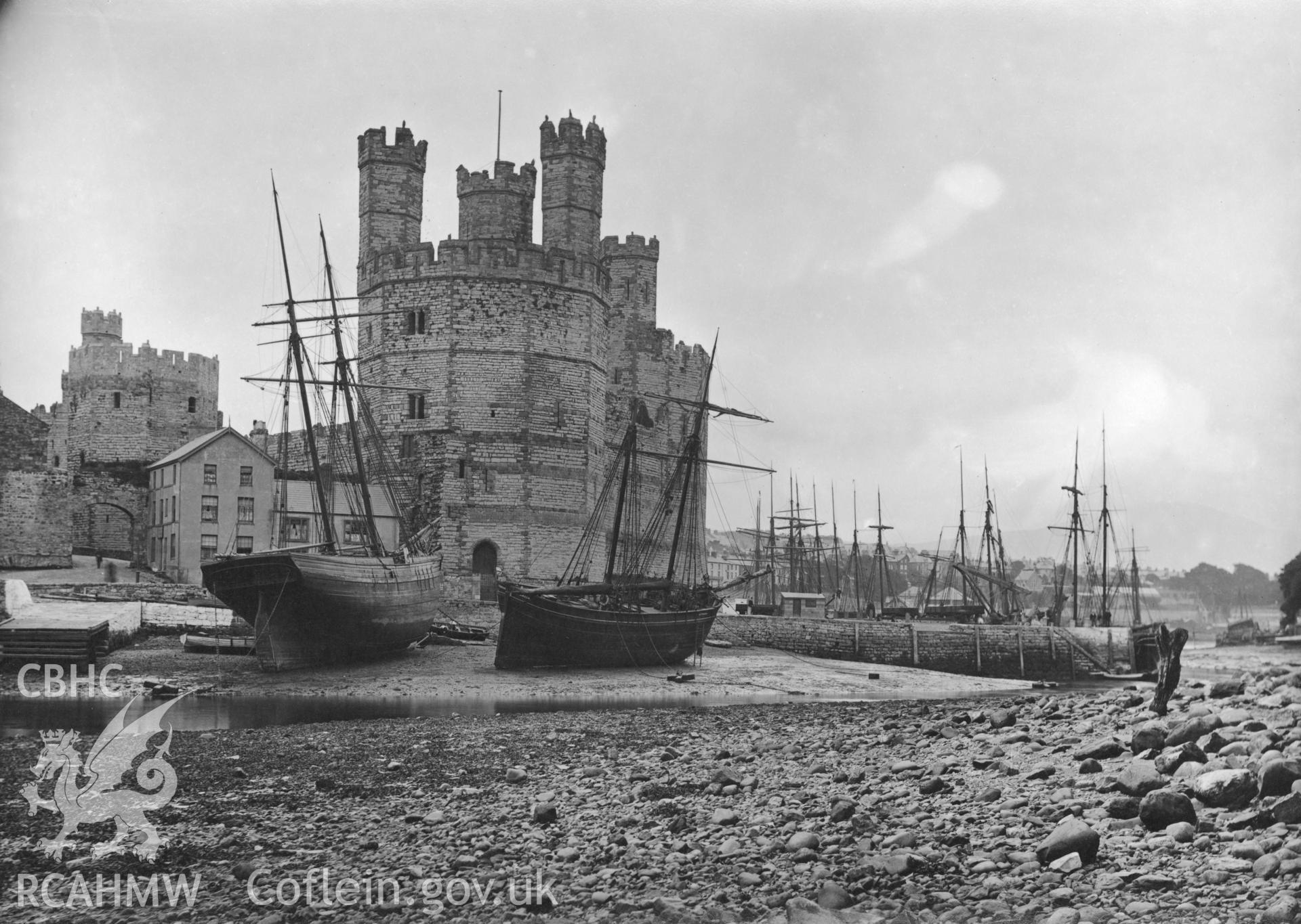 Caernarfon Castle and Afon Seiont ferry from the western bank, showing coastal trading vessel awaiting the tide.