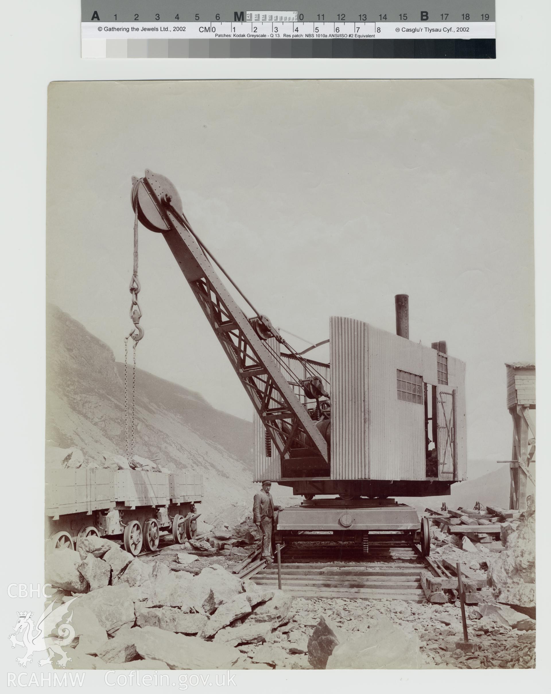Black and white photograph of the Elan Valley Water Scheme showing crane lifting broken rock into railway waggon. Copy negative held.