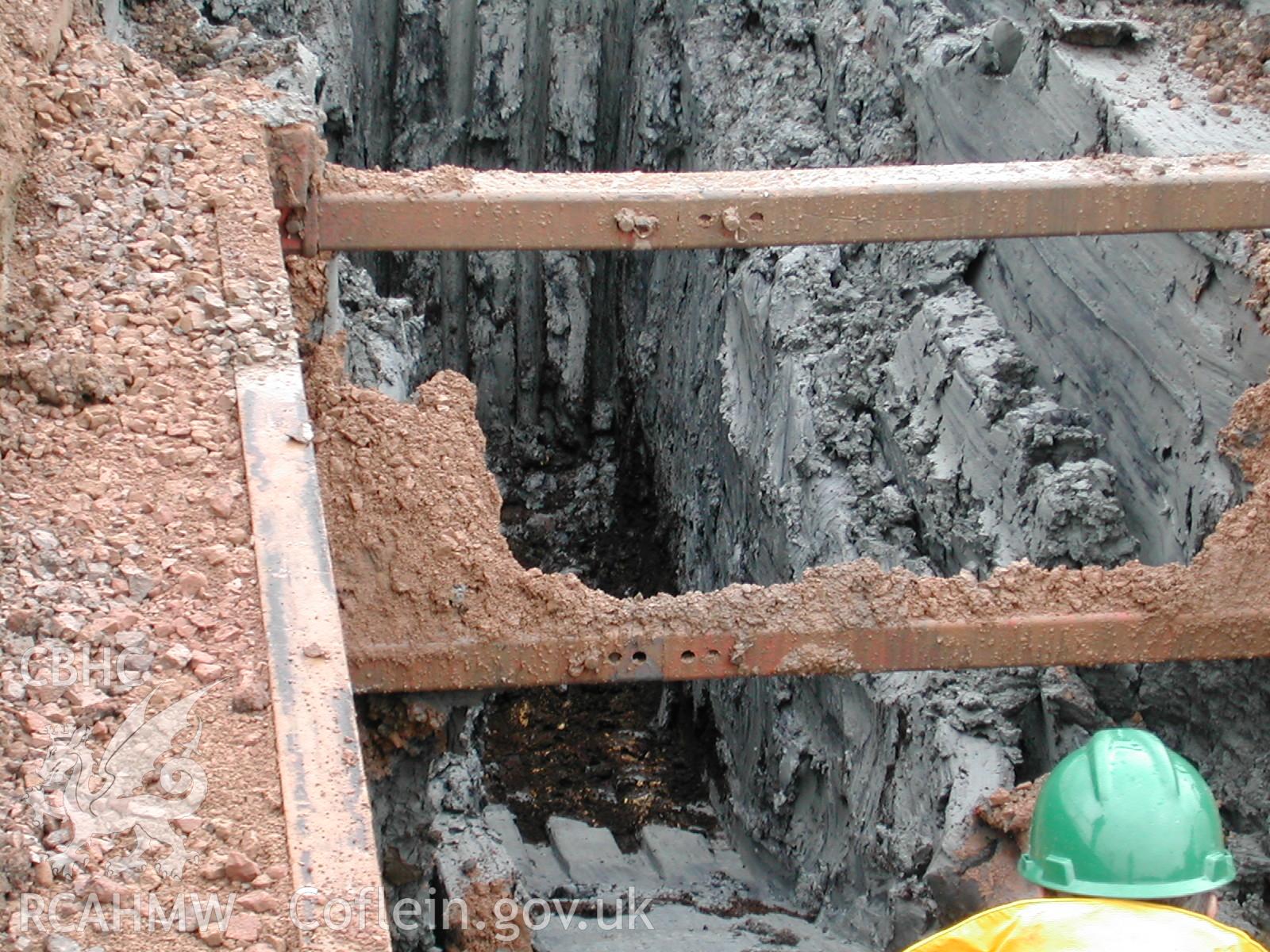 Colour digital photograph showing a deep peat layer at the base of a trench in the Ty Mawr Lane section, East terminal.