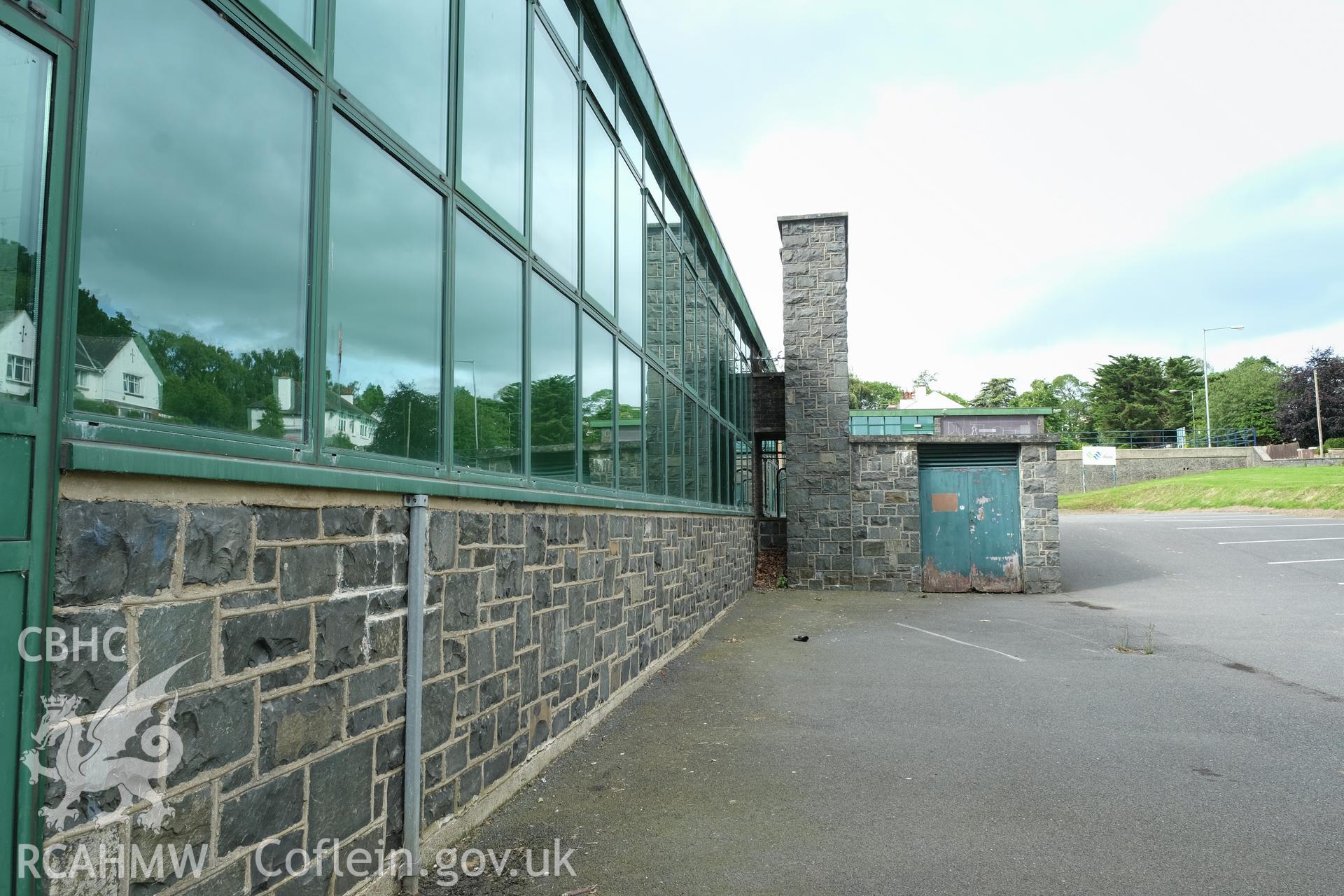 Digital colour photograph showing detailed exterior view of a heavily fenestrated and stone wall at Caernarfonshire Technical College, Bangor. Photographed by Dilys Morgan, donated by Wyn Thomas of Grwp Llandrillo-Menai Further Education College, 2019.