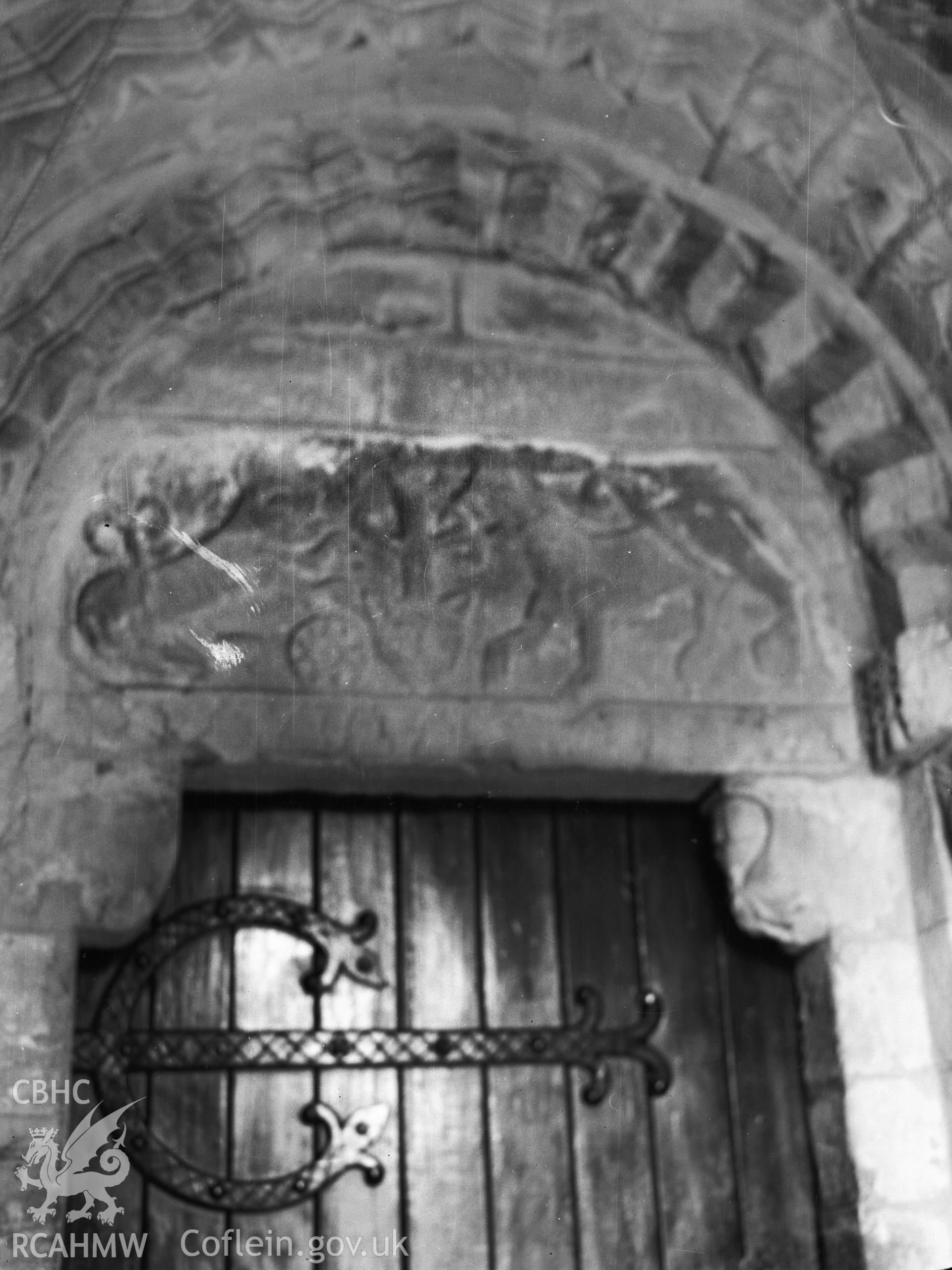 Digital copy of a nitrate negative showing interior view of carved tynpanum above Norman doorway, St Padarn's Church, Llanbadarn Fawr, Radnorshire. From the National Building Record Postcard Collection.