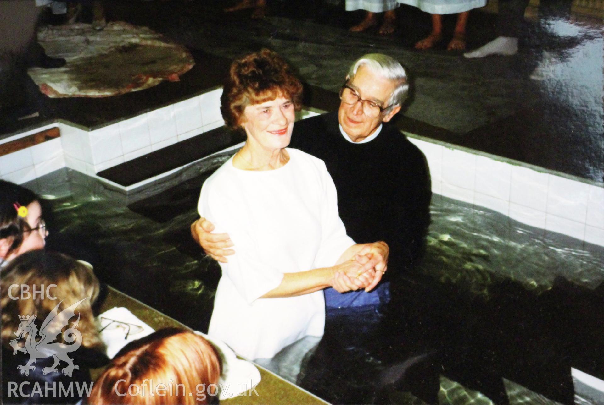 Colour photograph showing the minister baptising a member of the congregation at Riverside chapel, Port Talbot. Presumably photographed not long after the chapel was opened in 1974.
