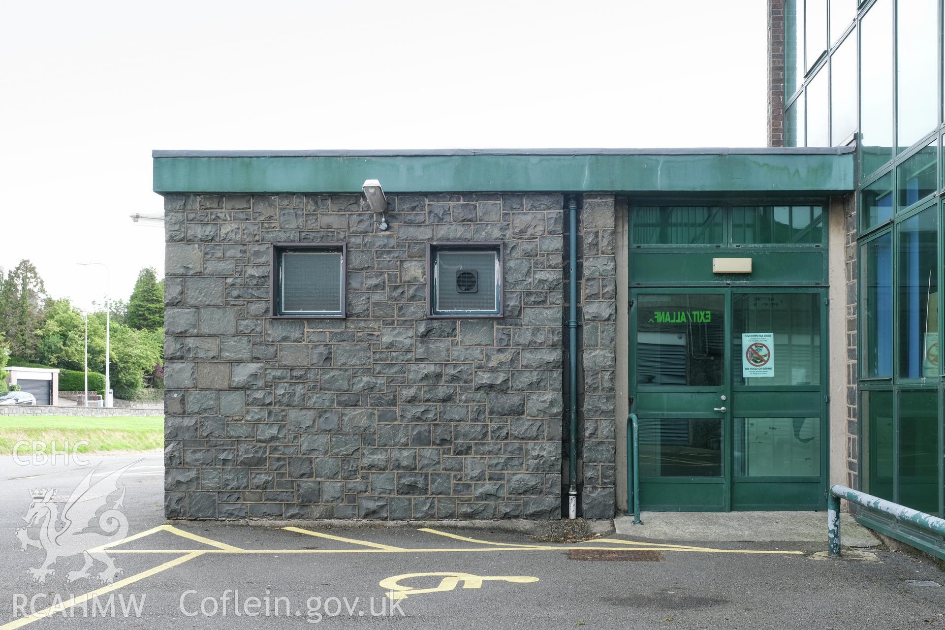 Digital colour photograph showing detailed exterior view of stone wall and entrance at Caernarfonshire Technical College, Bangor. Photographed by Dilys Morgan and donated by Wyn Thomas of Grwp Llandrillo-Menai Further Education College, 2019.