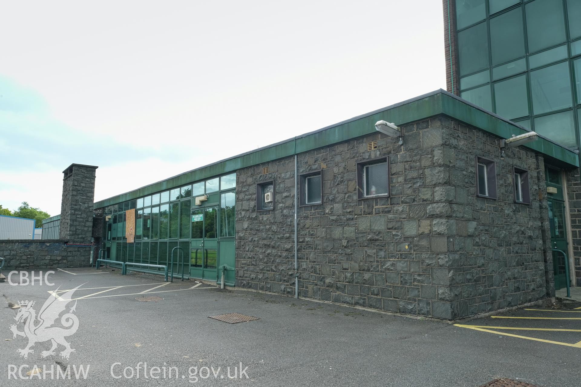 Digital colour photograph showing exterior view of a heavily fenestrated and stone wall at Caernarfonshire Technical College, Bangor. Photographed by Dilys Morgan and donated by Wyn Thomas of Grwp Llandrillo-Menai Further Education College, 2019.
