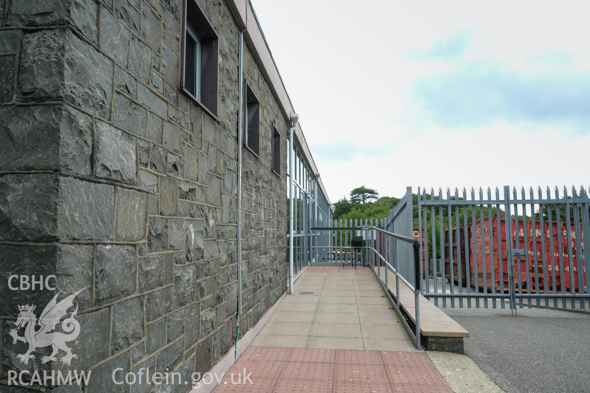 Colour photograph showing detailed exterior view of stone wall of single-storey part of building at Caernarfonshire Technical College, Bangor. Photographed by Dilys Morgan, donated by Wyn Thomas of Grwp Llandrillo-Menai Further Education College, 2019.