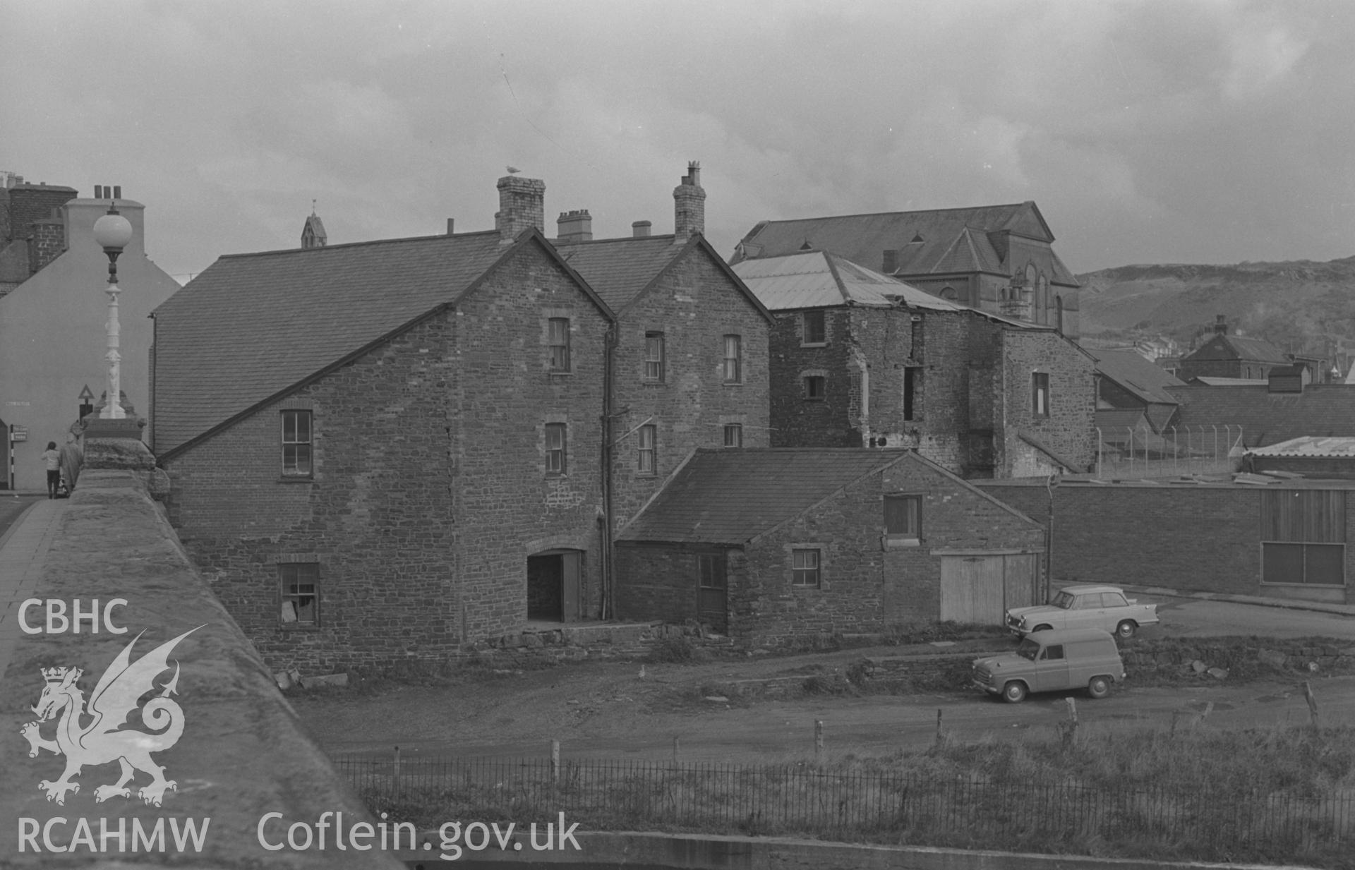 Digital copy of black & white negative showing view from Trefechan Bridge of rear of mill, foundry & laundry on Mill St., Tabernacle Chapel beyond, Aberystwyth. Photographed in September 1963 by Arthur O. Chater, SN 58278 81310, looking north north east.